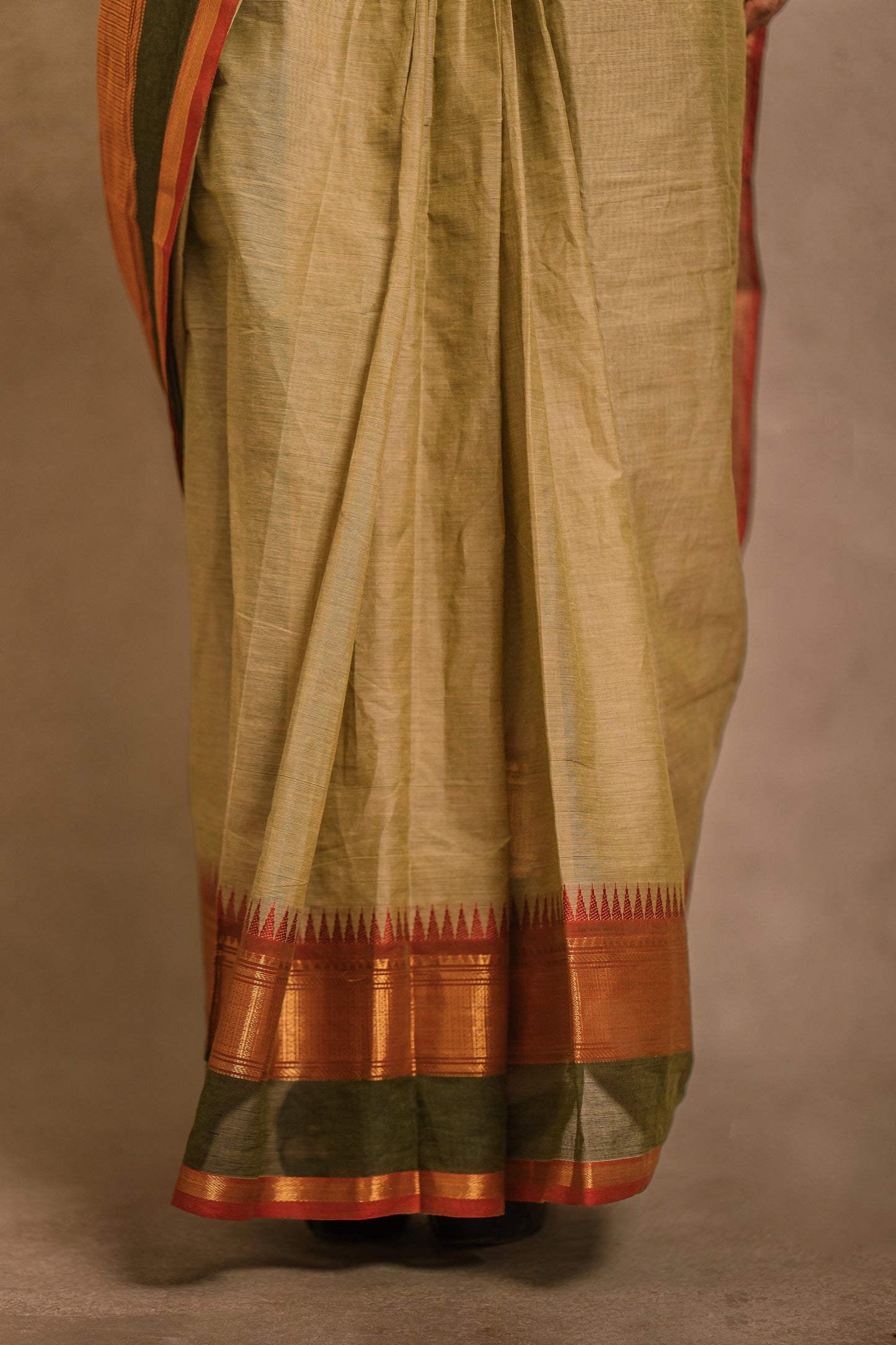 Border of a draped saree in sage green with a hand embroidered blouse in maroon & green by team AKloset.