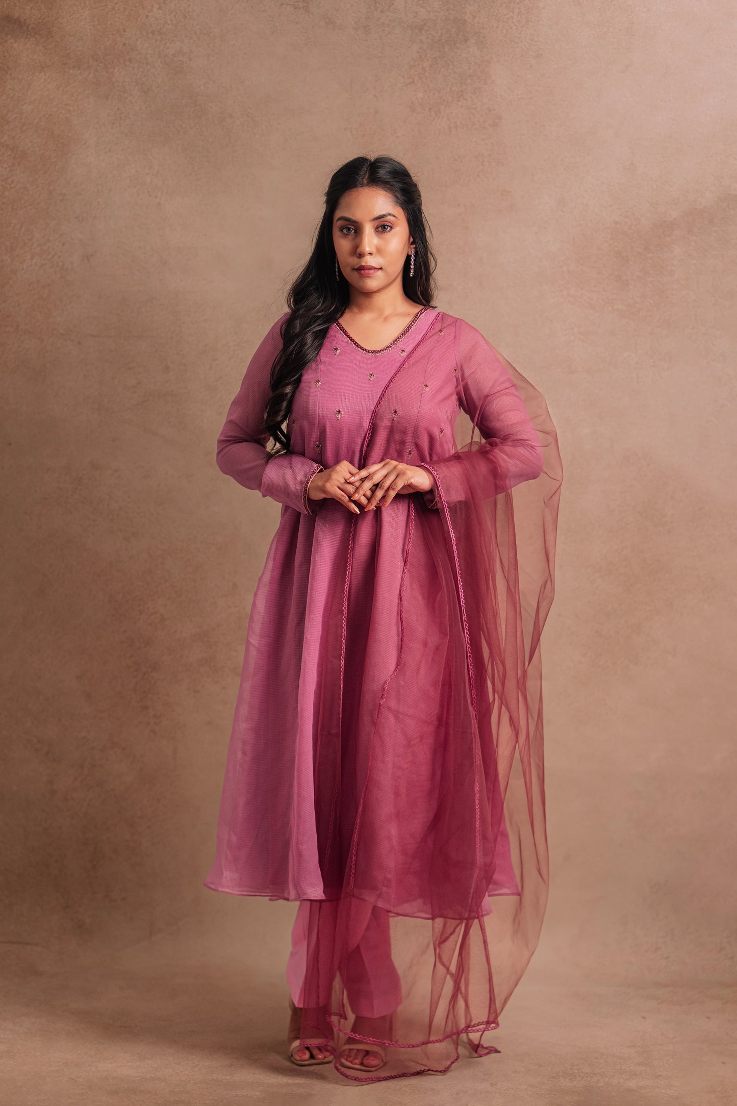 Model Dolly Aishwarya in a hand embroidered tissue chiffon salwar set in onion pink paired with a tulle dupatta by team AKloset.