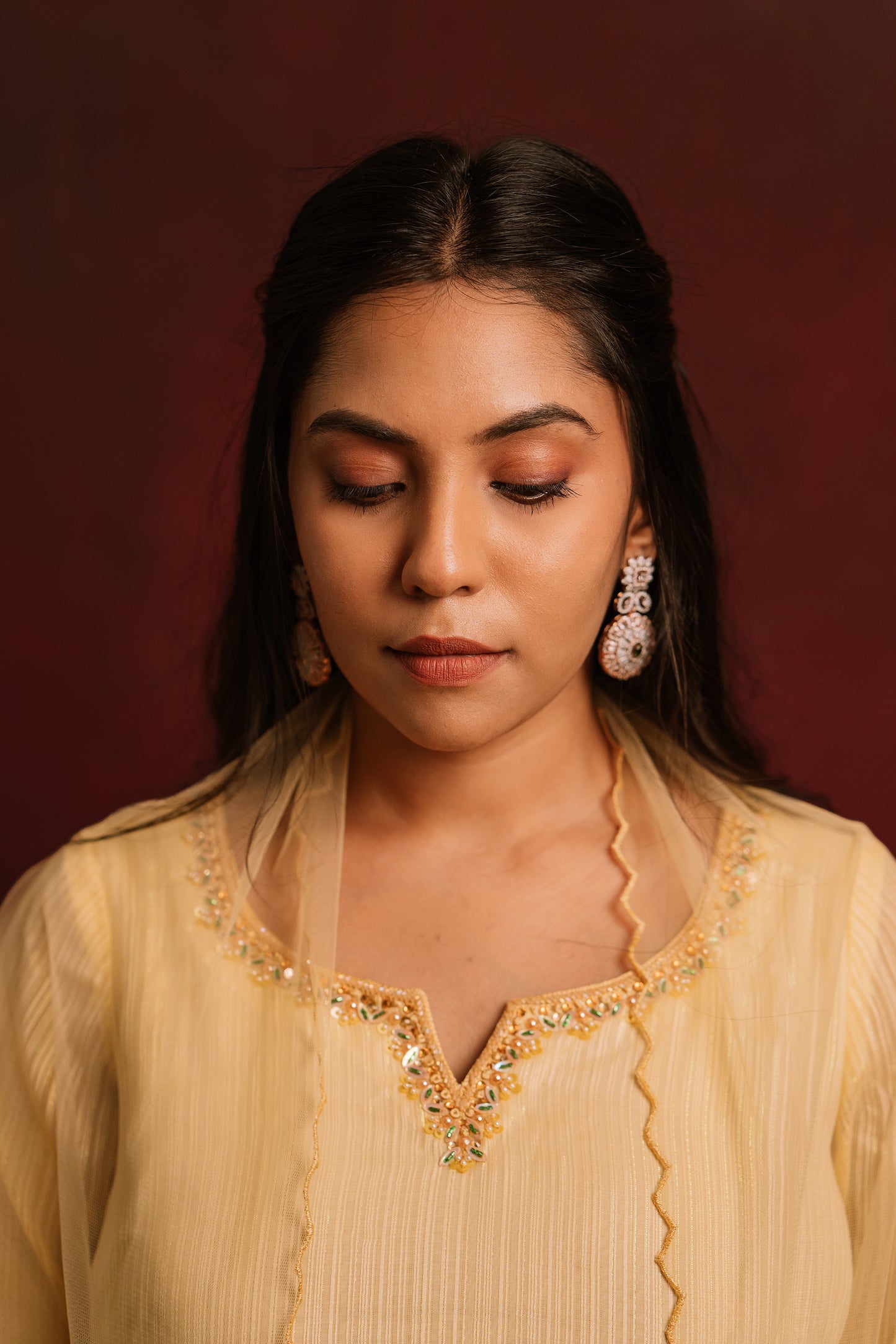 Model Dolly Aishwarya posing for closeup detailing in a hand embroidered chiffon salwar set in yellow paired with a tulle dupatta by team AKloset.