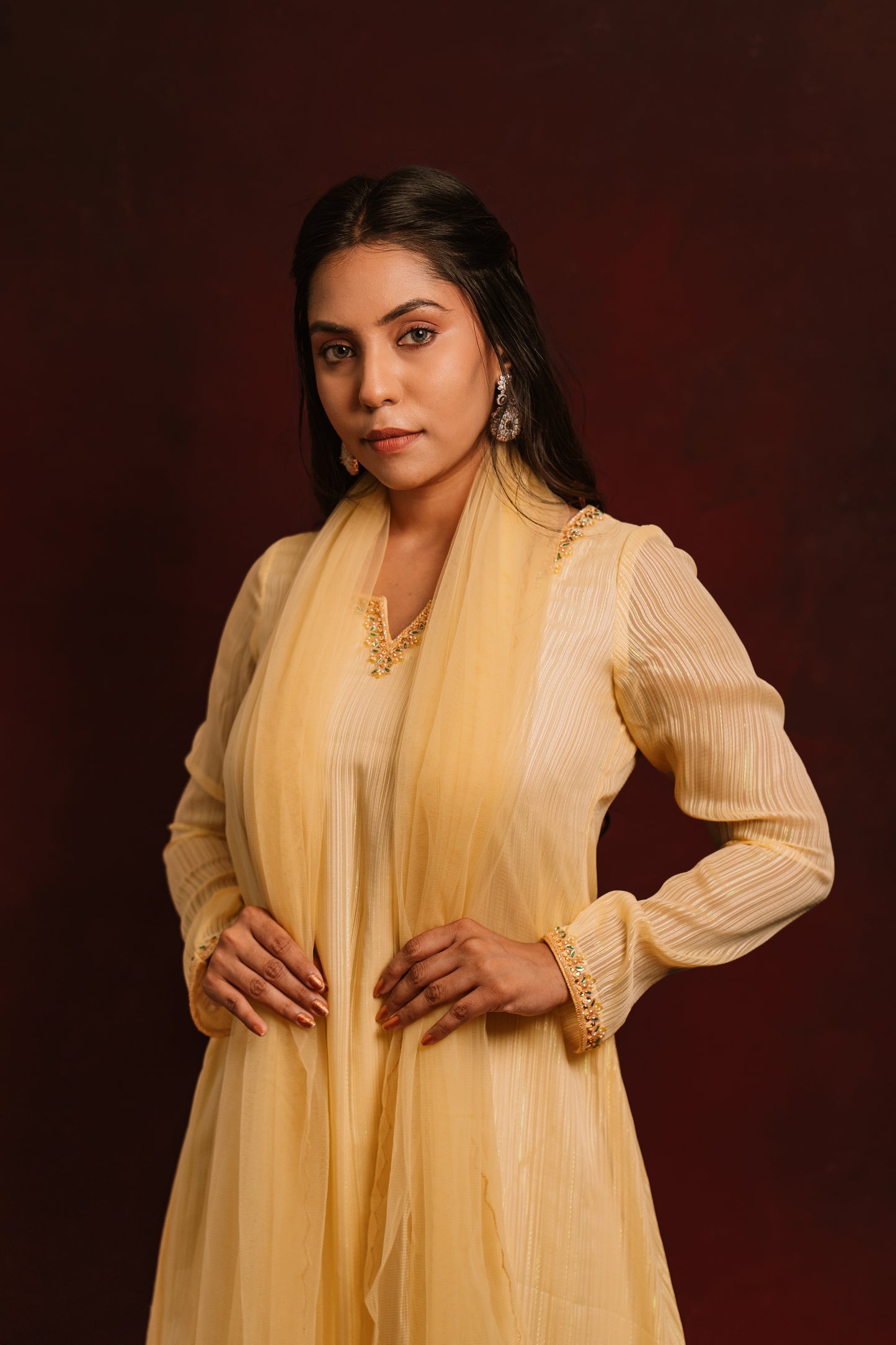 Model Dolly Aishwarya posing in a hand embroidered chiffon salwar set in yellow paired with a tulle dupatta by team AKloset.