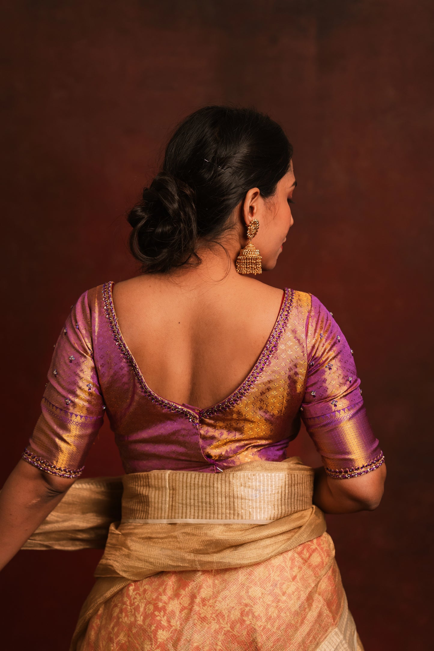Model Dolly Aishwarya showcases back blouse design in a handcrafted kanjivaram tissue blouse in purple (Dual Tone Silk) by team AKloset. Fashionable, high-quality craftsmanship that is stylish and affordable.