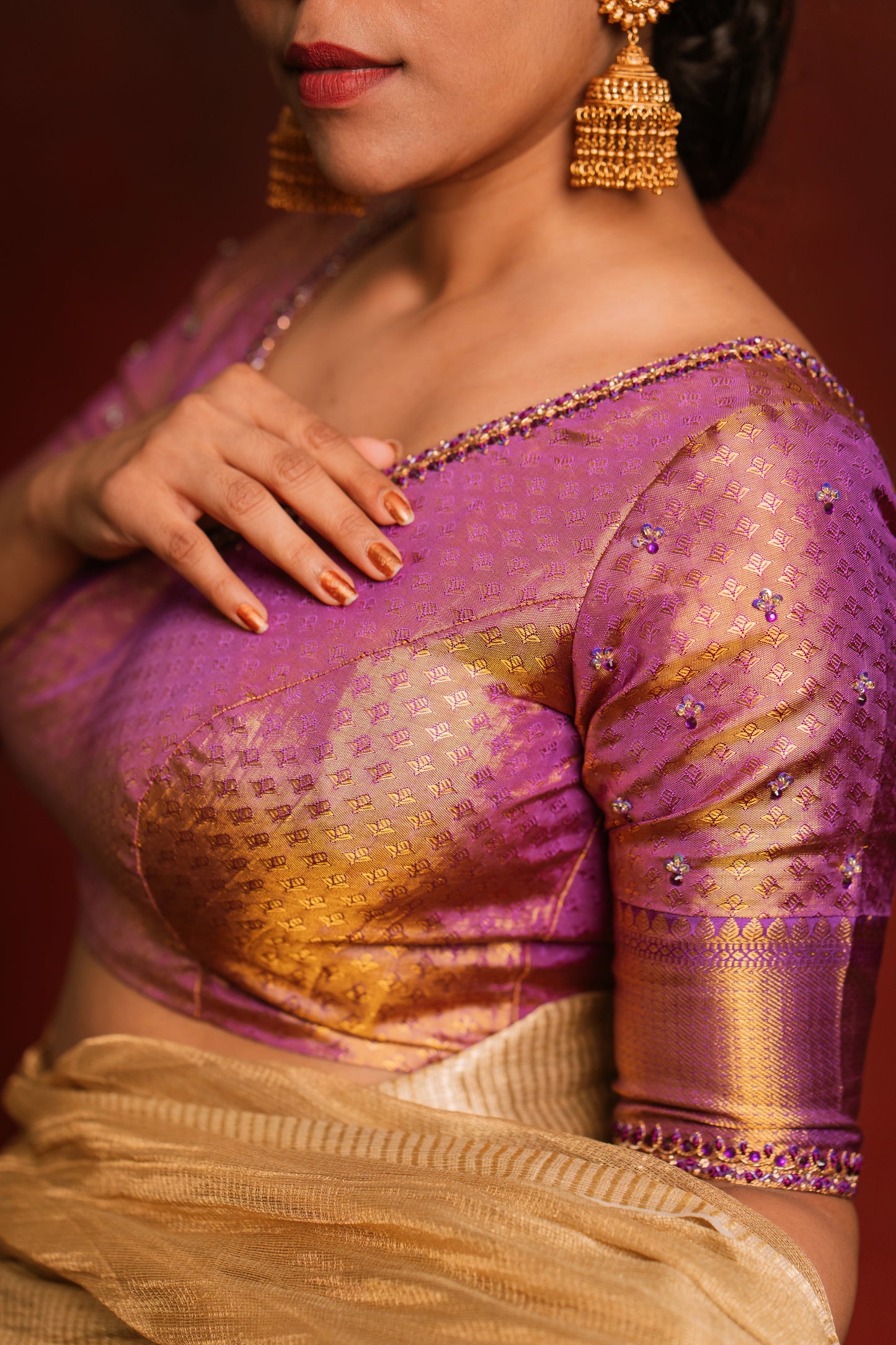 Model Dolly Aishwarya showcases neckline & sleeve in a handcrafted kanjivaram tissue blouse in purple (Dual Tone Silk) by team AKloset. Fashionable, high-quality craftsmanship that is stylish and affordable.