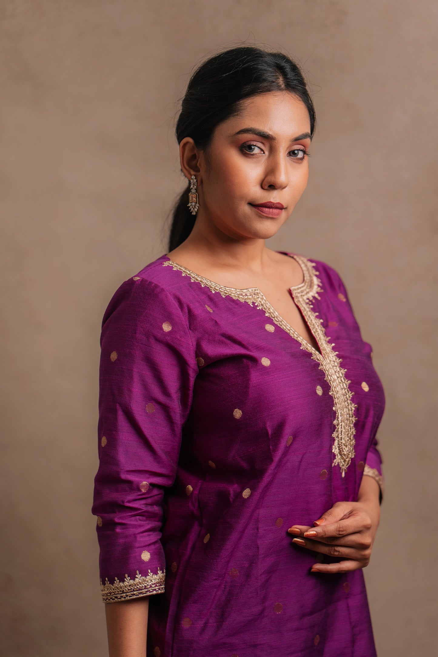 Model Dolly Aishwarya showcasing neckline and sleeve in an embroidered jute cotton kurti set in magenta by team AKloset.