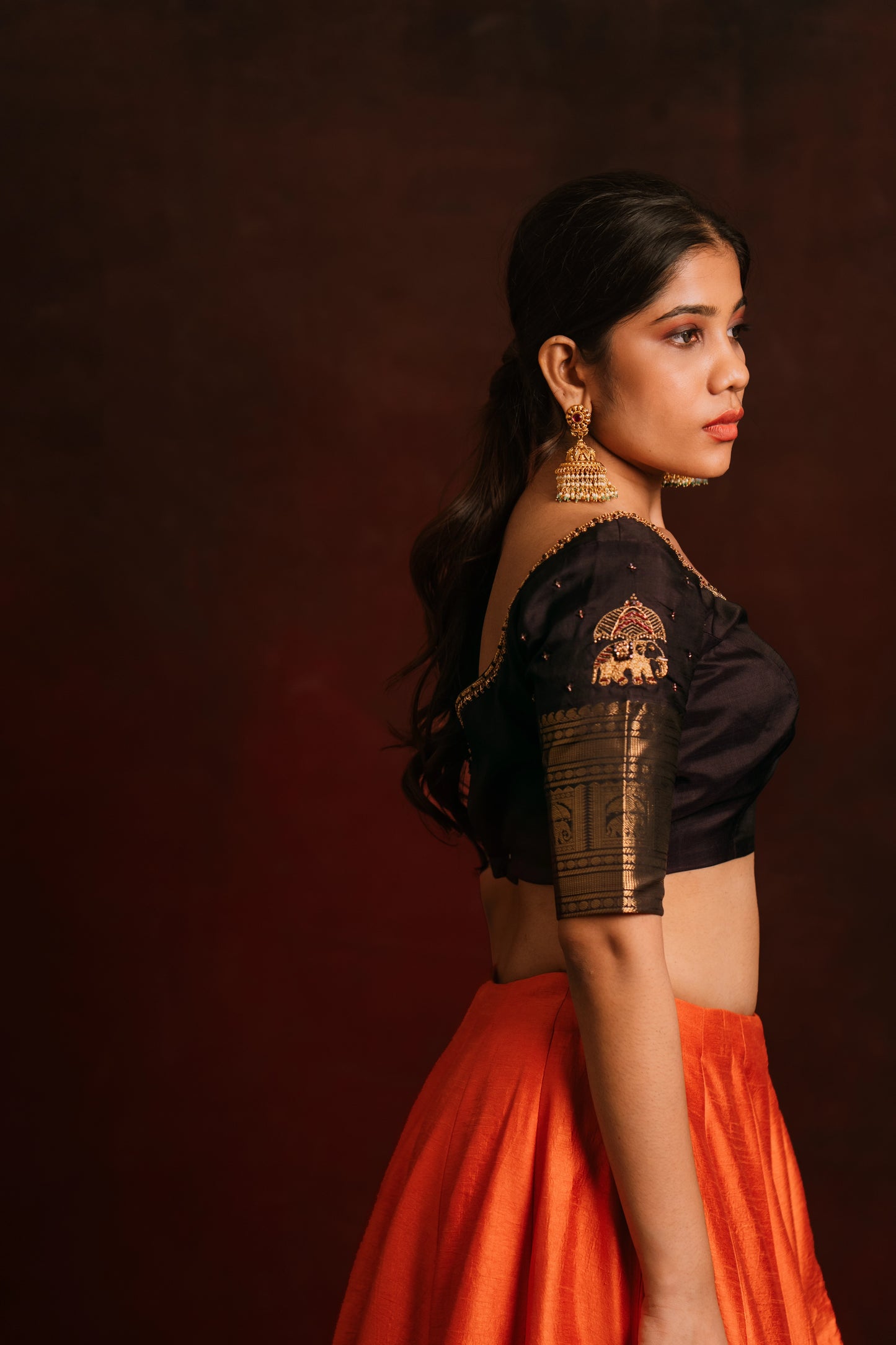 Model Jaina Parmar poses in a hand embroidered kanjivaram silk blouse in brown by team AKloset. Fashionable, high-quality craftsmanship that is stylish and affordable.