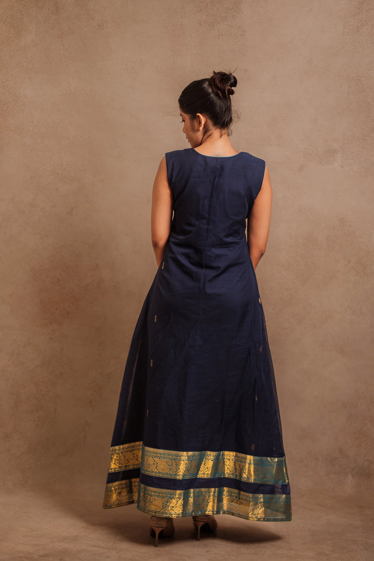Model Jaina Parmar posing for back design in a sleeveless a-line dress in blue by team AKloset.