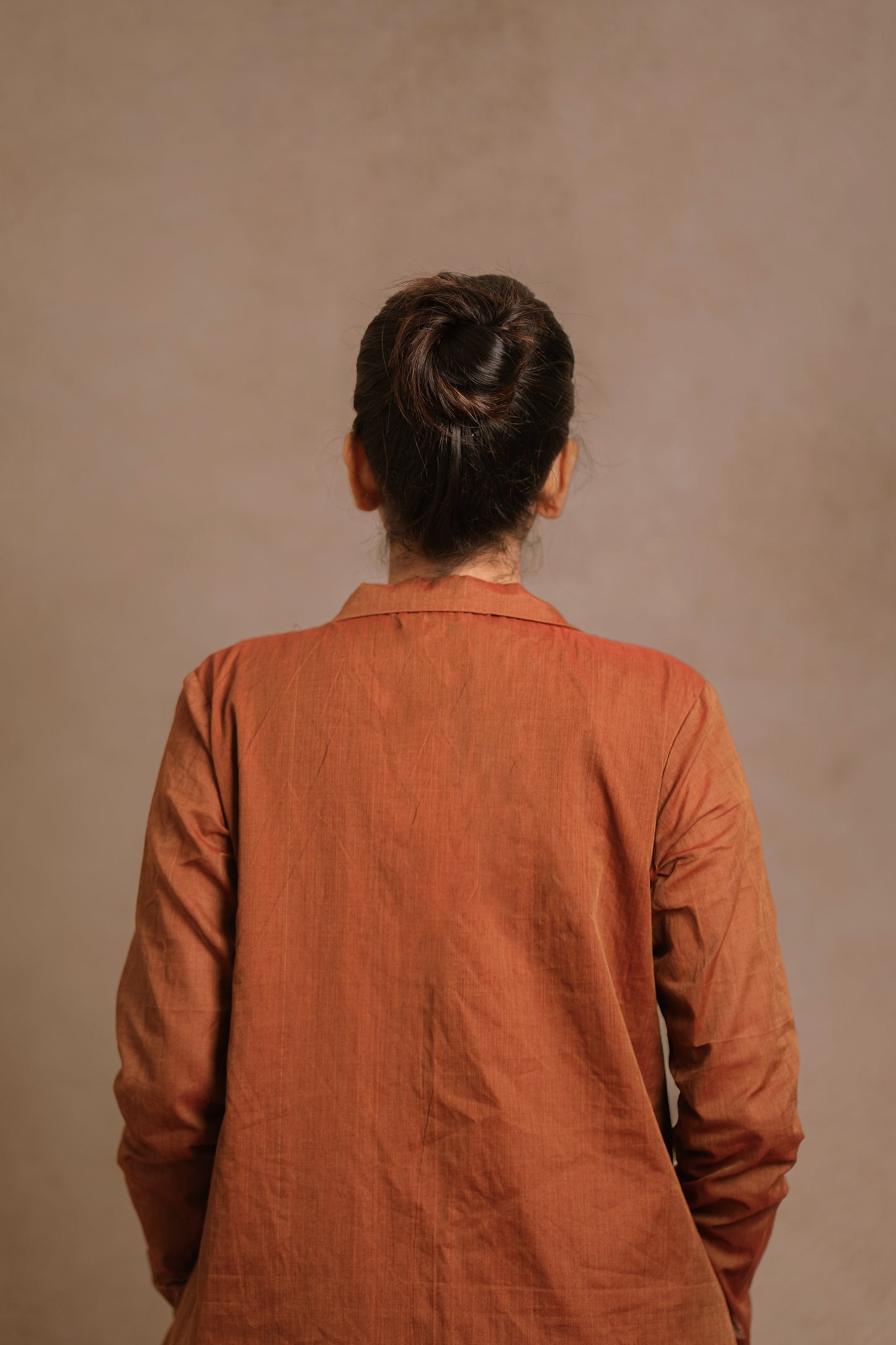 Model Jaina Parmar posing for back profile in a brown co-ord set by team AKloset.