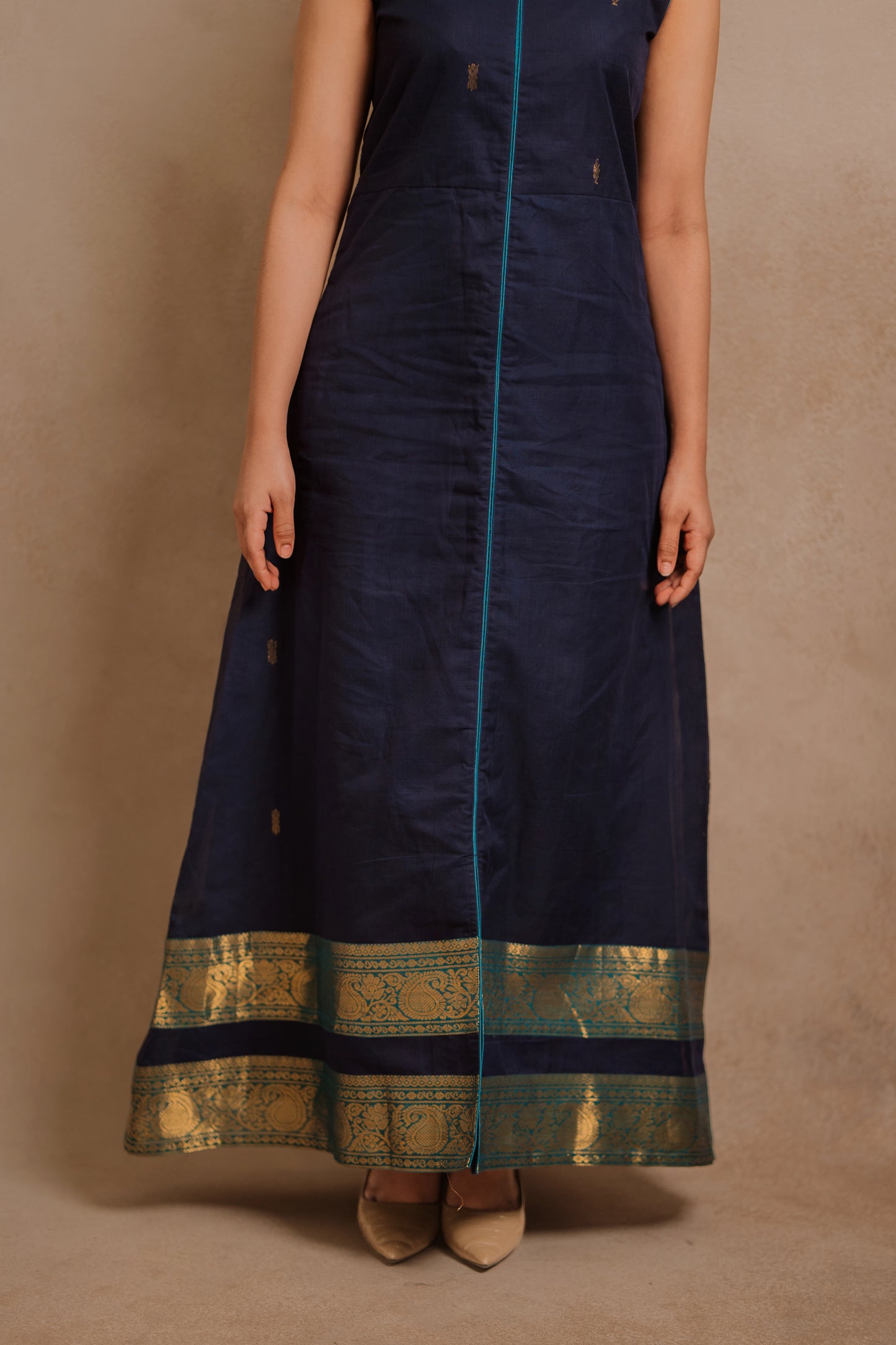 Model Jaina Parmar posing for border closeup in a sleeveless a-line dress in blue by team AKloset.
