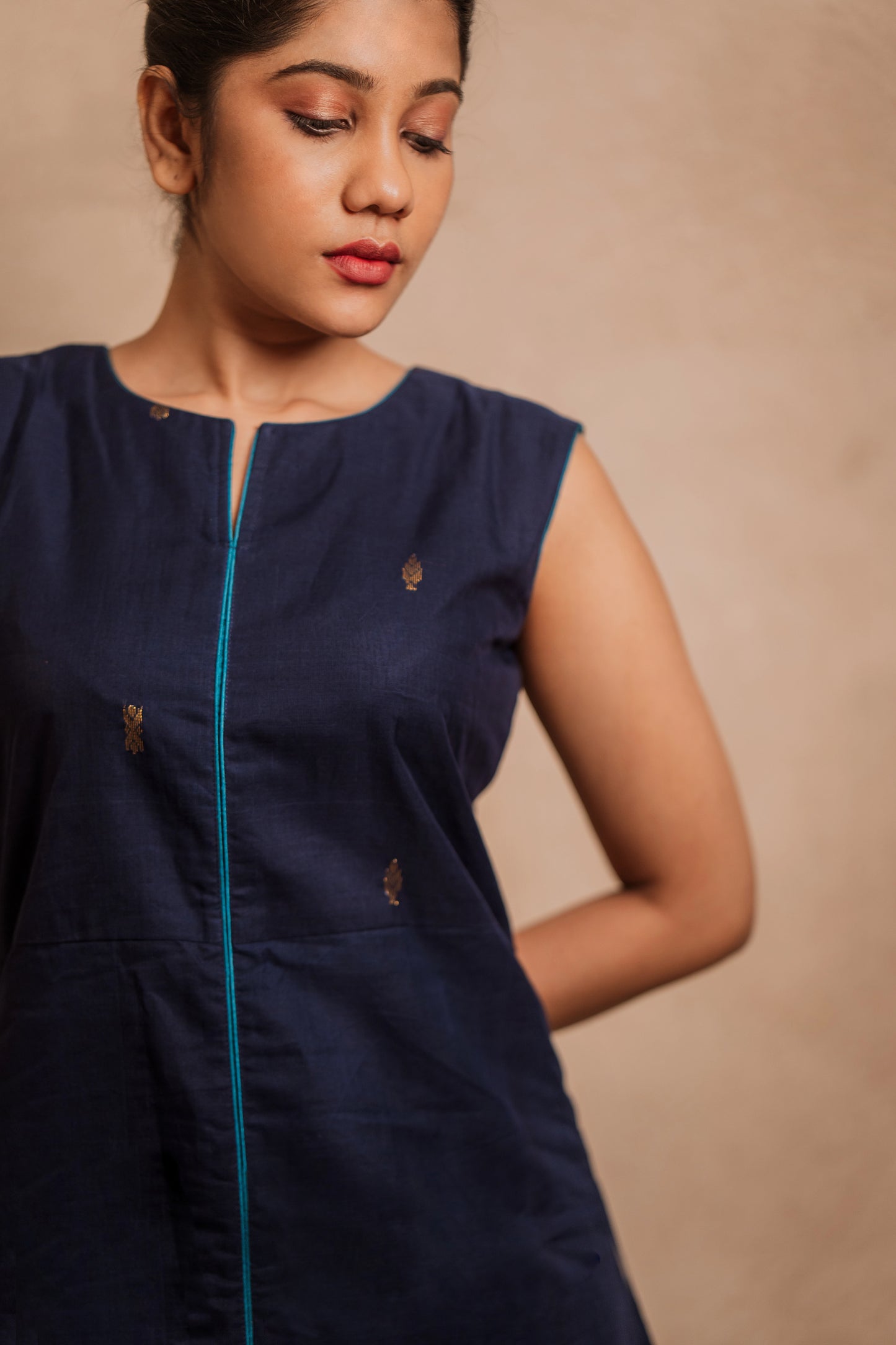 Model Jaina Parmar posing for closeup in a sleeveless a-line dress in blue by team AKloset.