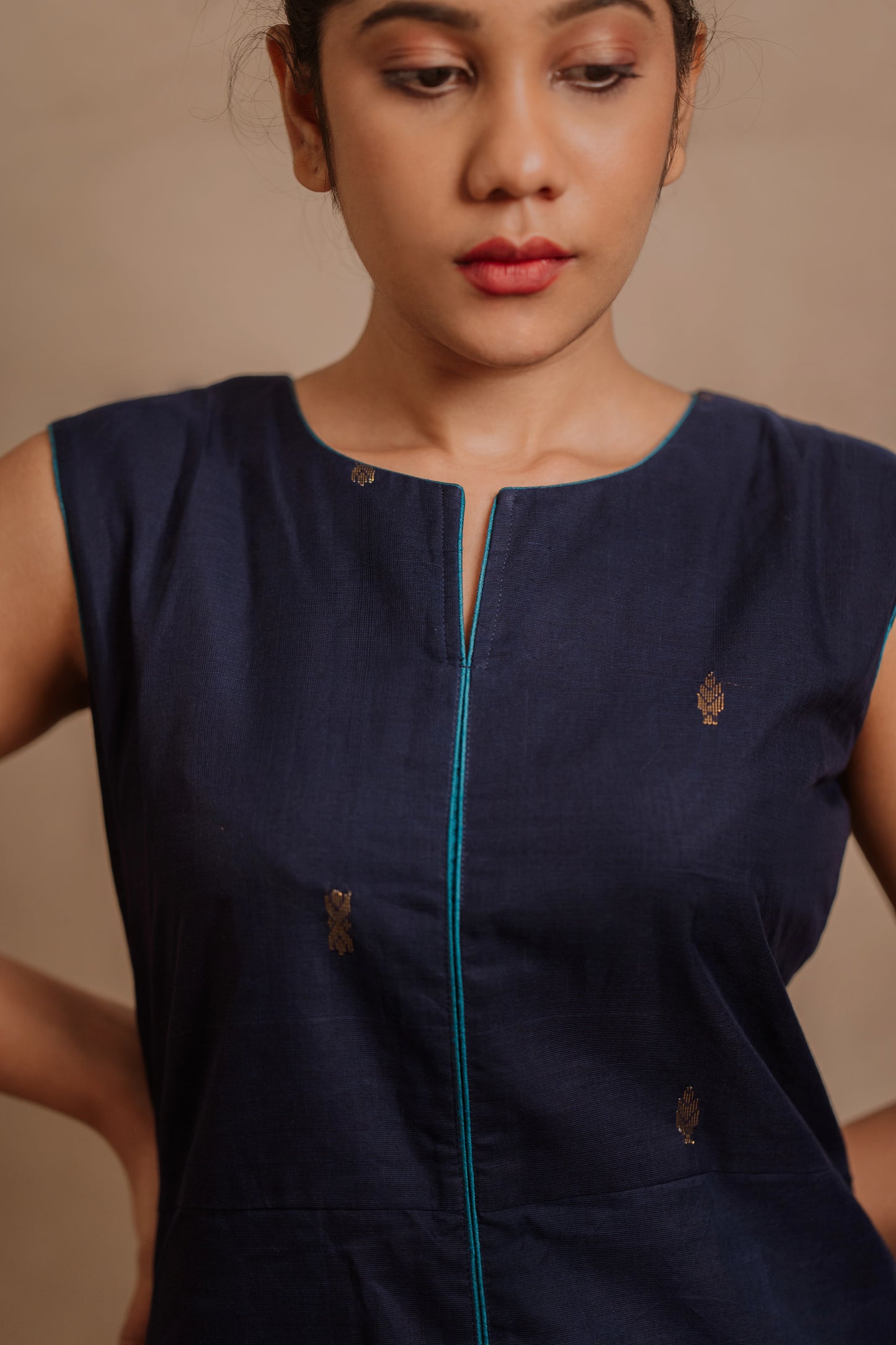Model Jaina Parmar posing for yoke closeup in a sleeveless a-line dress in blue by team AKloset.