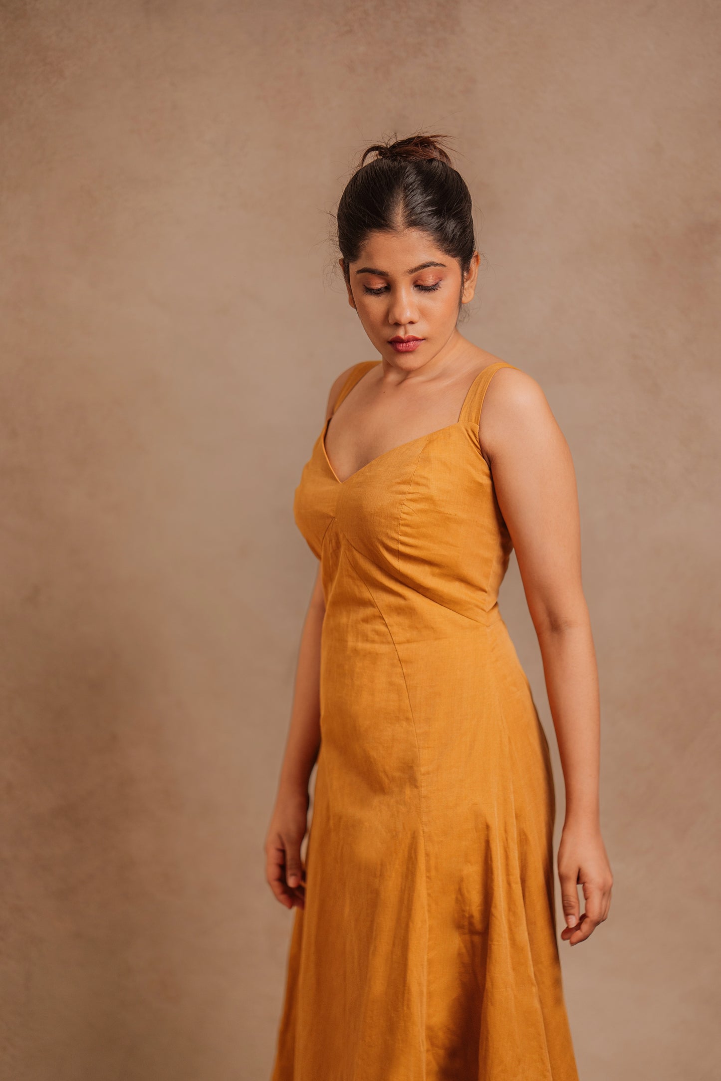 Model Jaina Parmar posing for yoke in a corset dress in mustard by team AKloset.
