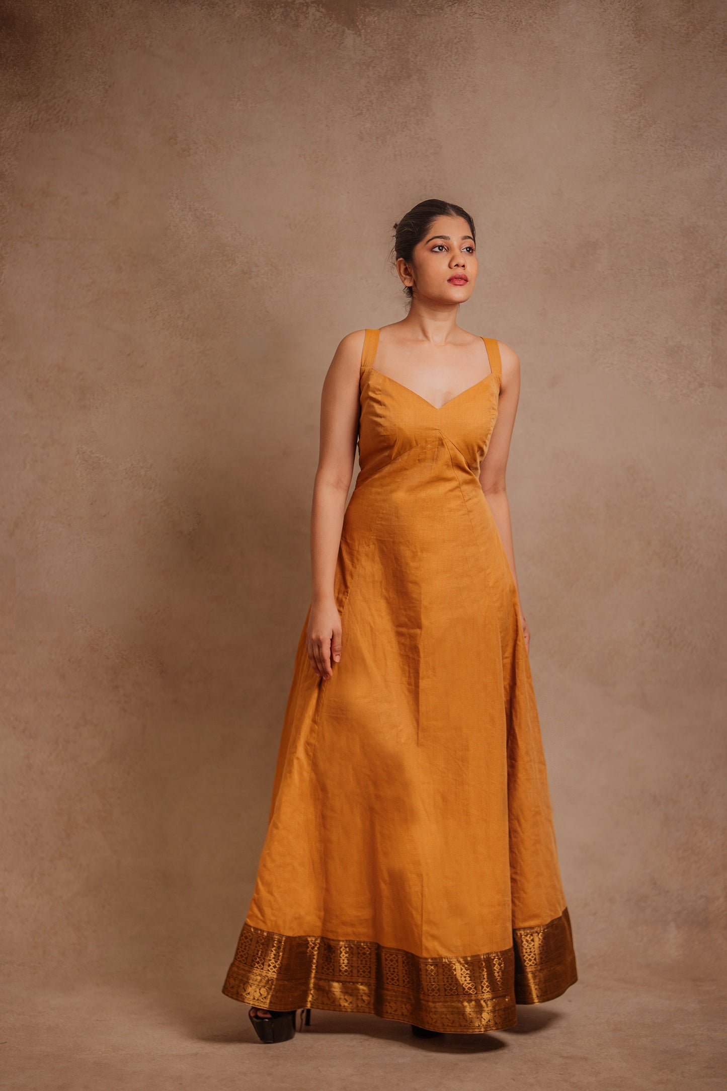 Model Jaina Parmar posing in a corset dress in mustard by team AKloset.