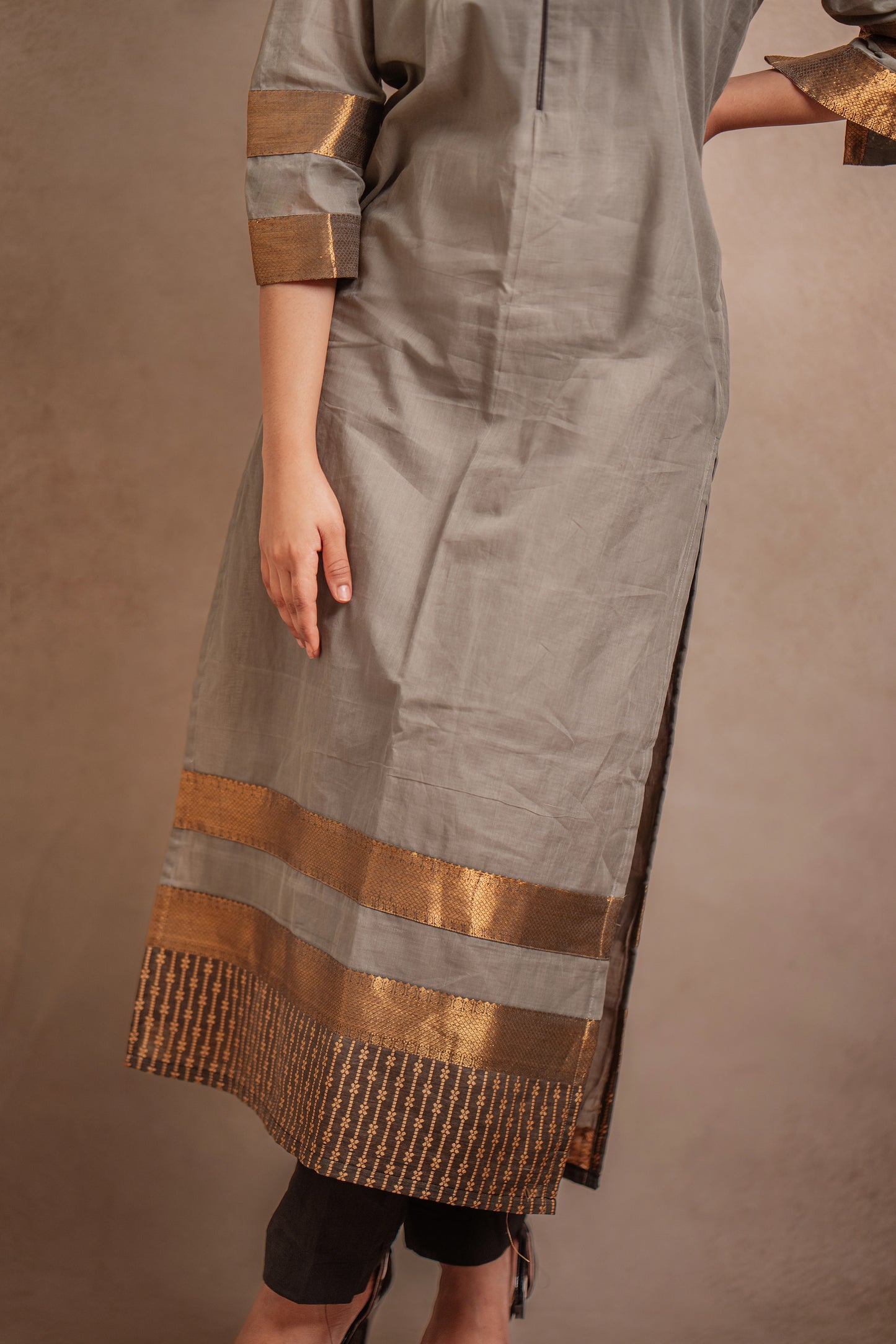 Model Jaina Parmar posing in an oversized kurti in gray with bell sleeves paired with a black pant by team AKloset.