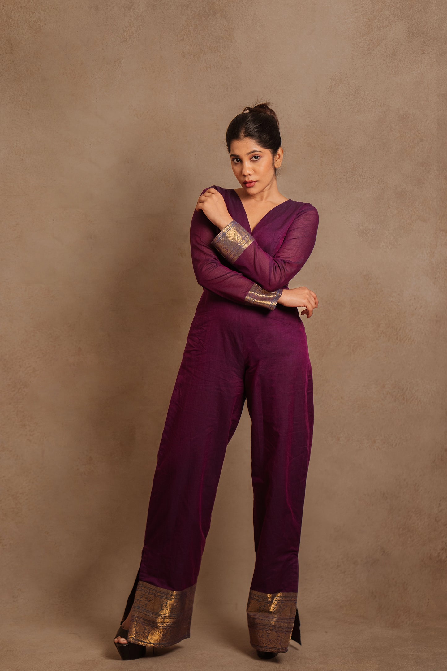 Model Jaina Parmar posing stylishly in a v-neck purple jumpsuit with a stylish low slit by team AKloset.