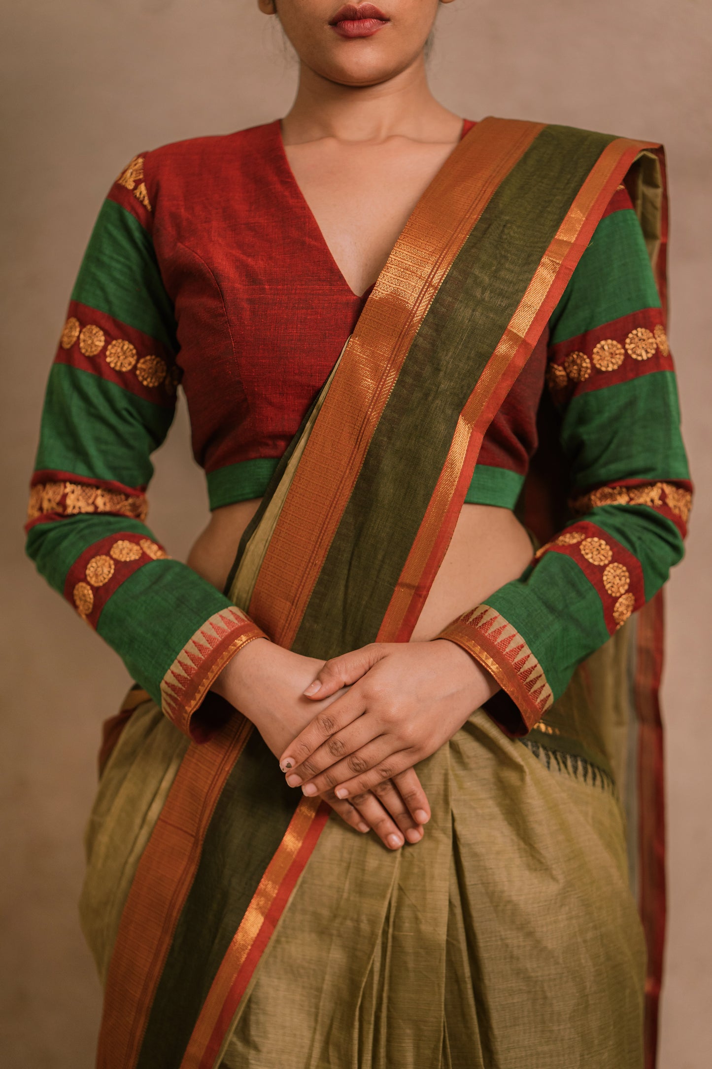 Model Jaina Parmar showcasing detailing in a draped saree in sage green with a hand embroidered blouse in maroon & green by team AKloset.
