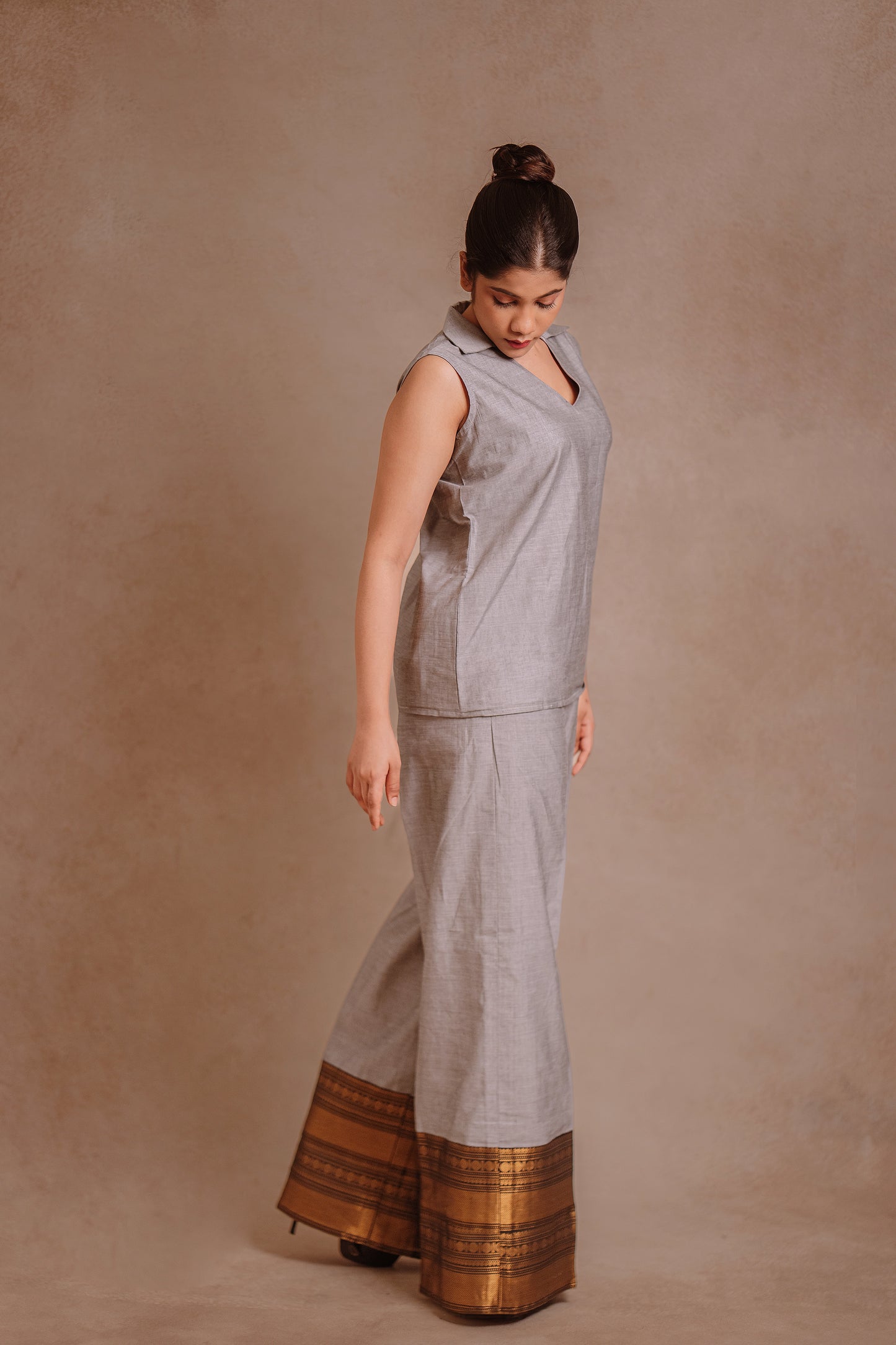 Model Jaina Parmar showcasing side profile in a sleeveless co-ord set in gray by team AKloset.