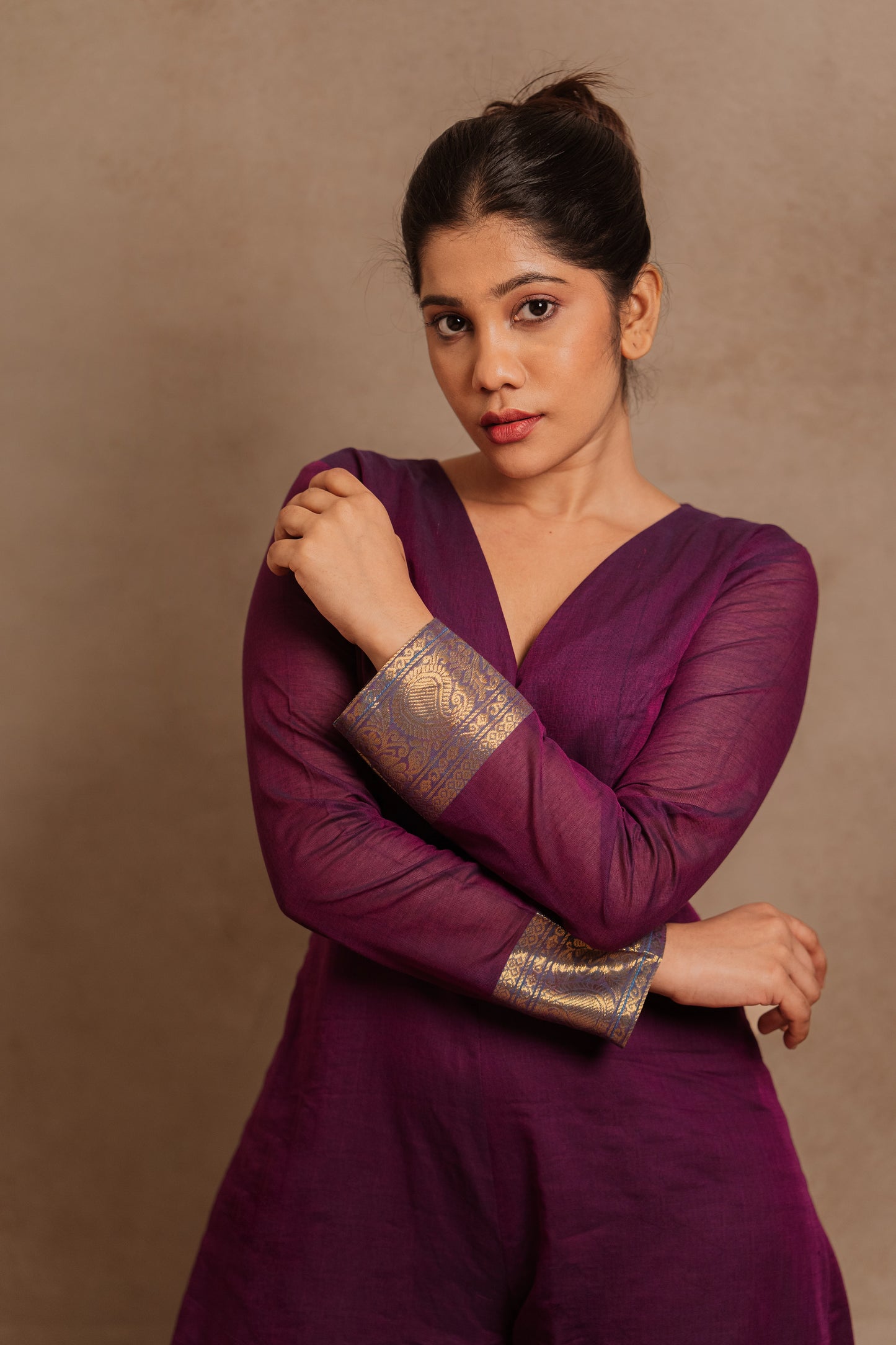 Model Jaina Parmar showcasing sleeve detailing in a v-neck purple jumpsuit with a stylish low slit by team AKloset.