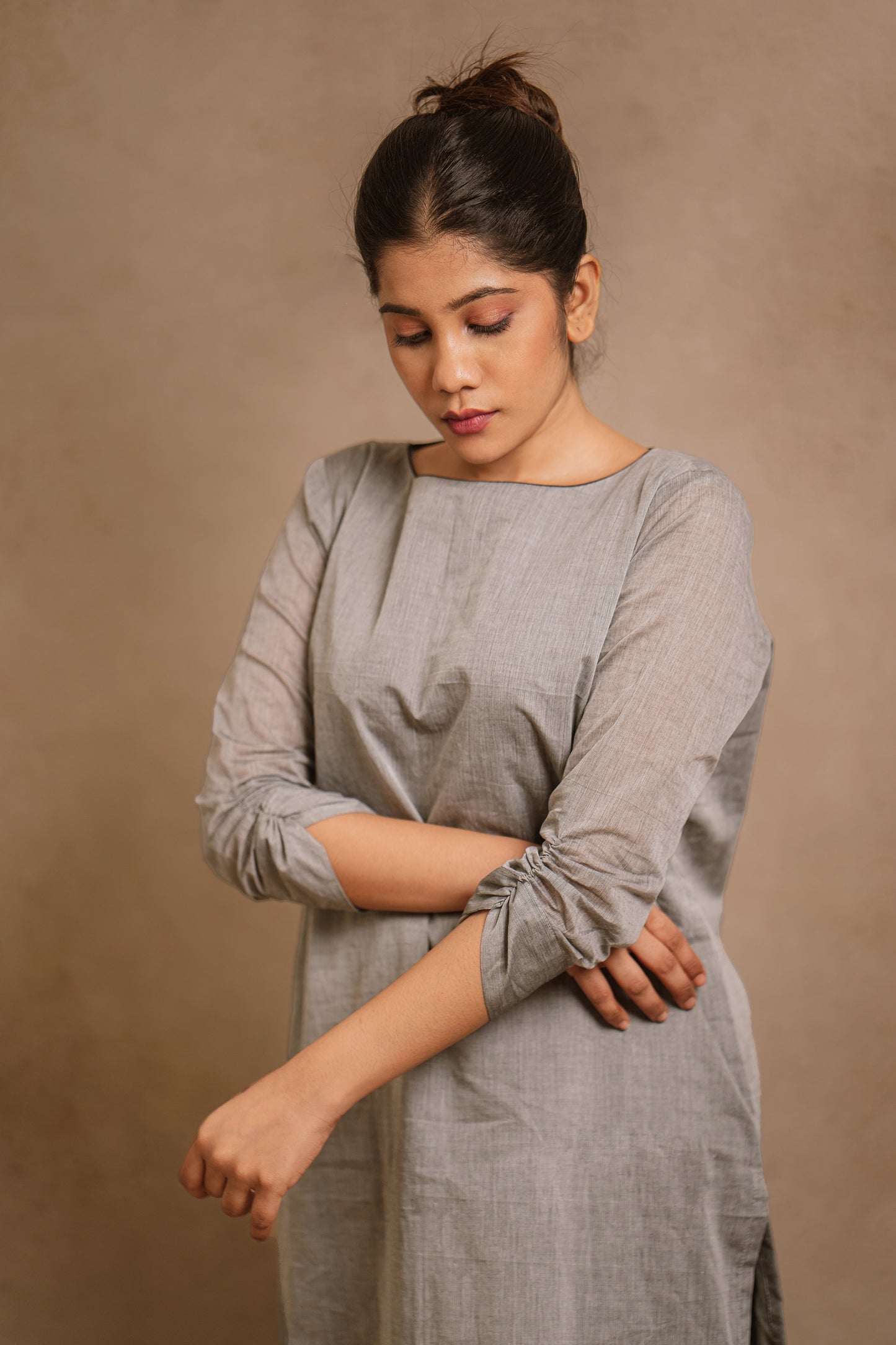 Model Jaina Parmar showcasing sleeve in an oversized gray kurti by team AKloset. A South Edit (Kanjivaram) piece is differentiated by the extravagant border native to Kanjivaram.
