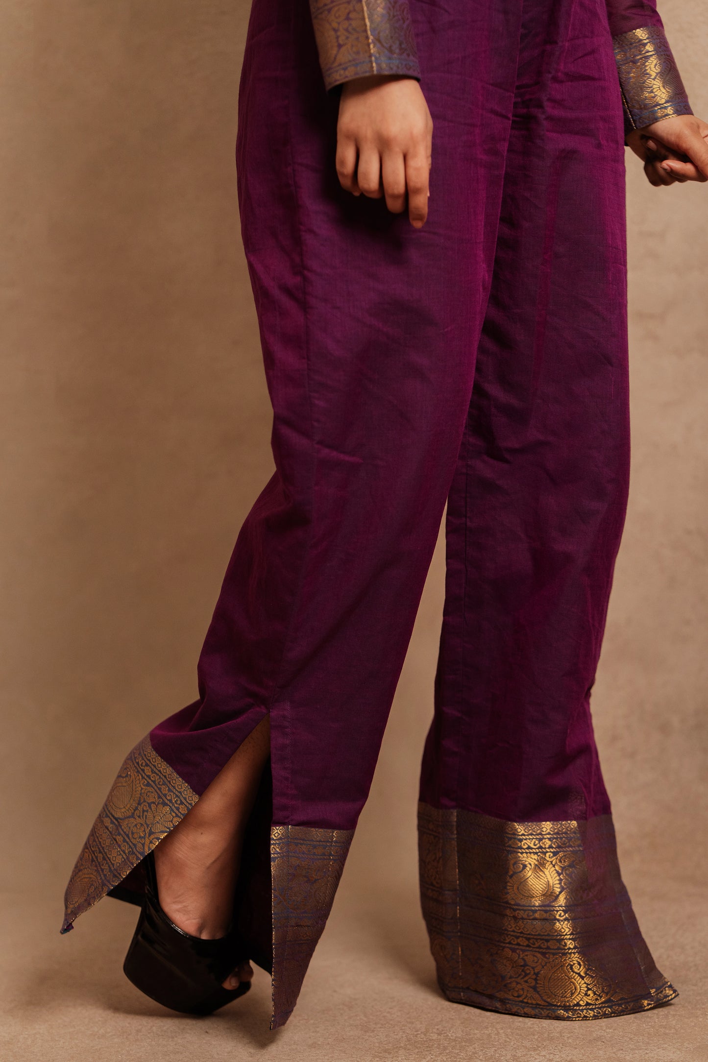 Model Jaina Parmar showcasing slit detailing at the ankles in a v-neck purple jumpsuit with a stylish low slit by team AKloset.