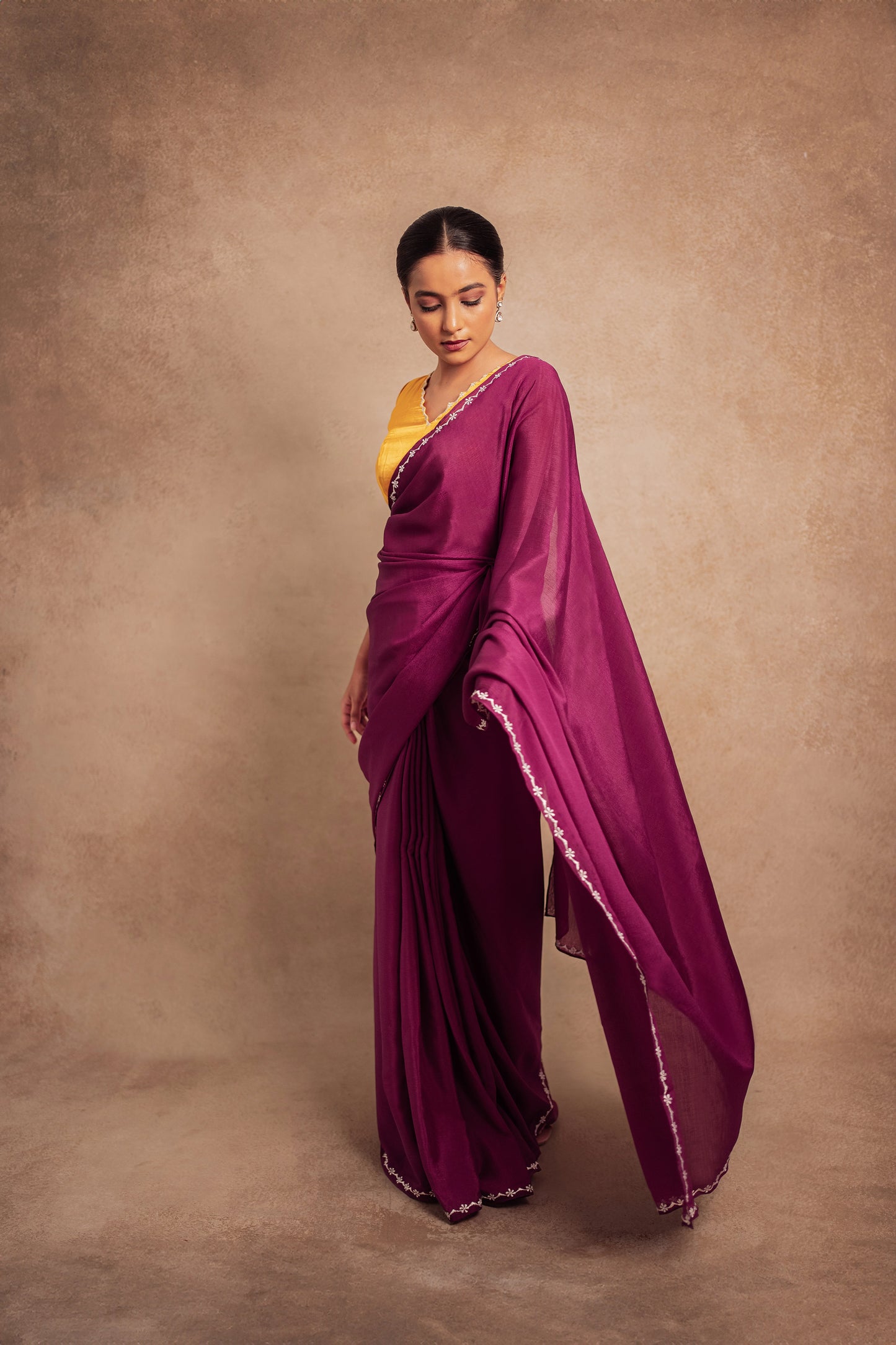 Model Krisha during a photoshoot in embroidered shimmer chiffon saree in purple paired with an embroidered mustard yellow chanderi blouse by AKloset.