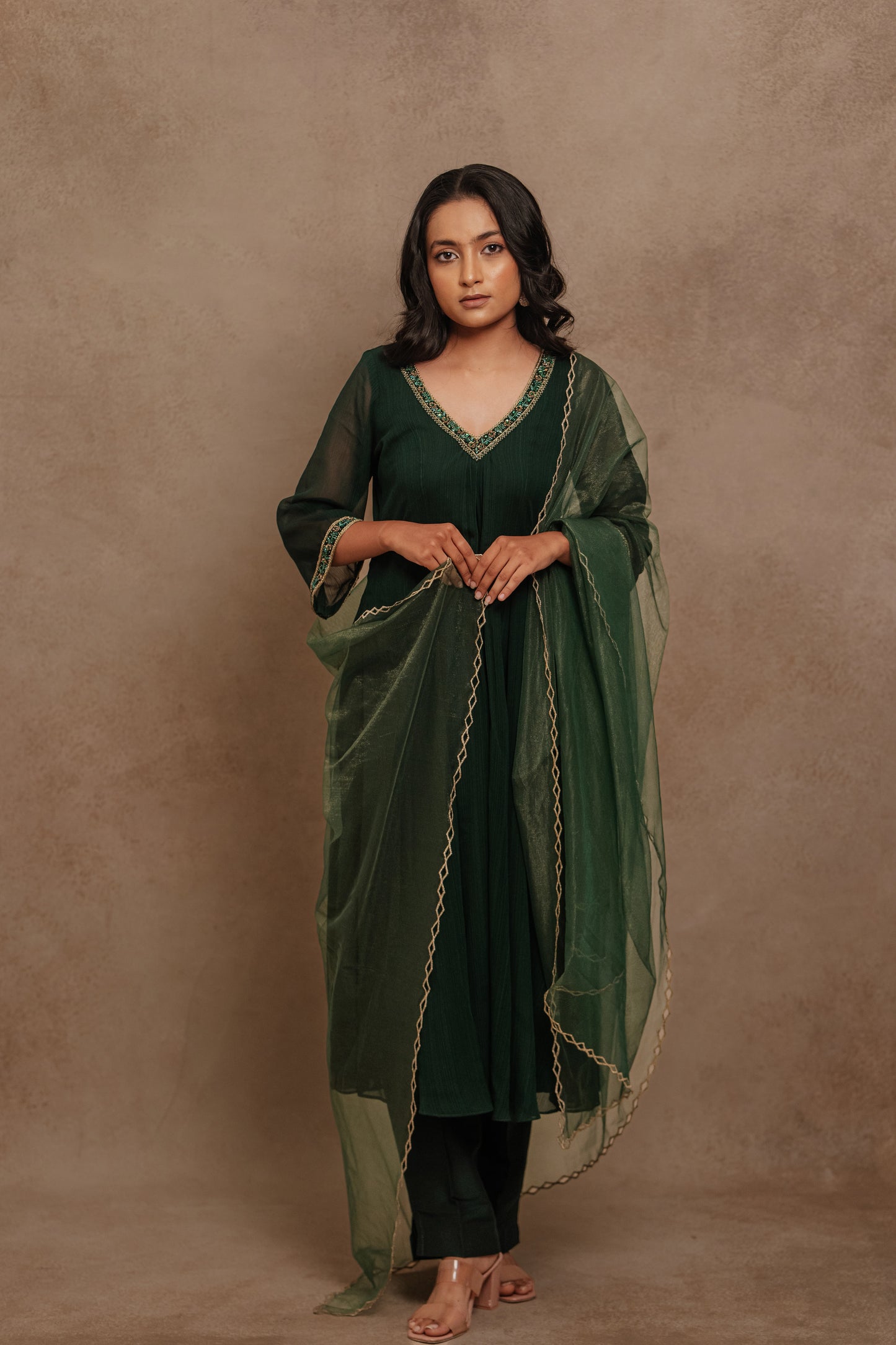 Model Krisha in a hand embroidered tissue chiffon anarkali set in bottle green paired with a matching shimmer dupatta by team AKloset.