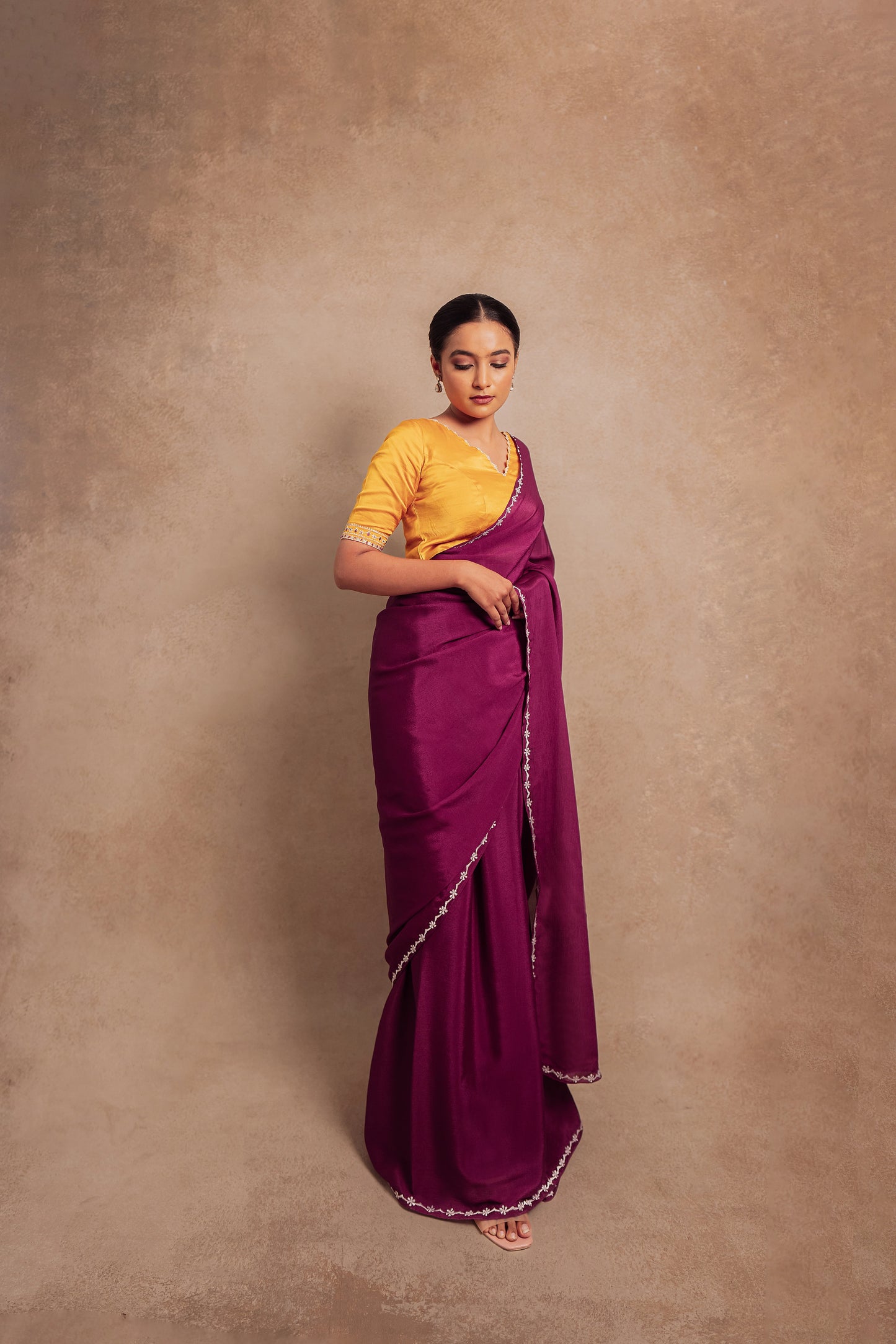 Model Krisha posing for photoshoot in embroidered shimmer chiffon saree in purple paired with an embroidered mustard yellow chanderi blouse by AKloset.