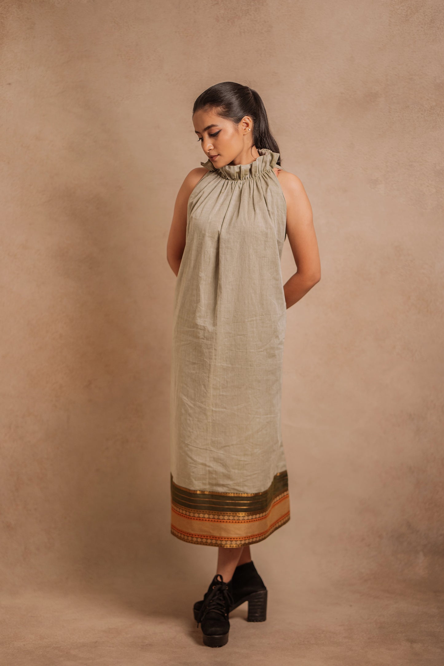 Model Krisha posing in a halterneck dress in sage green with a Halterneck by team Akloset.