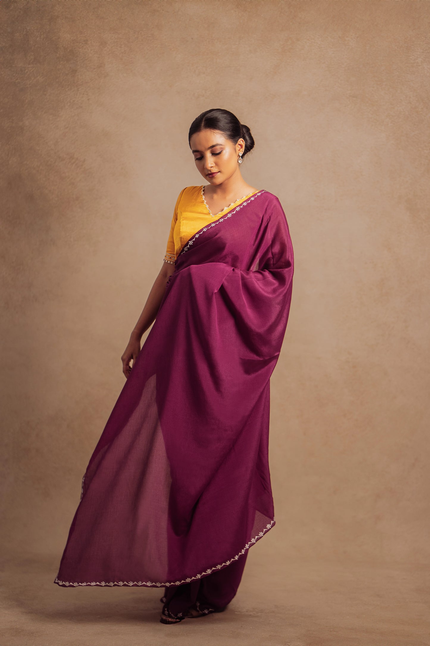 Model Krisha posing in embroidered shimmer chiffon saree in purple paired with an embroidered mustard yellow chanderi blouse by AKloset.
