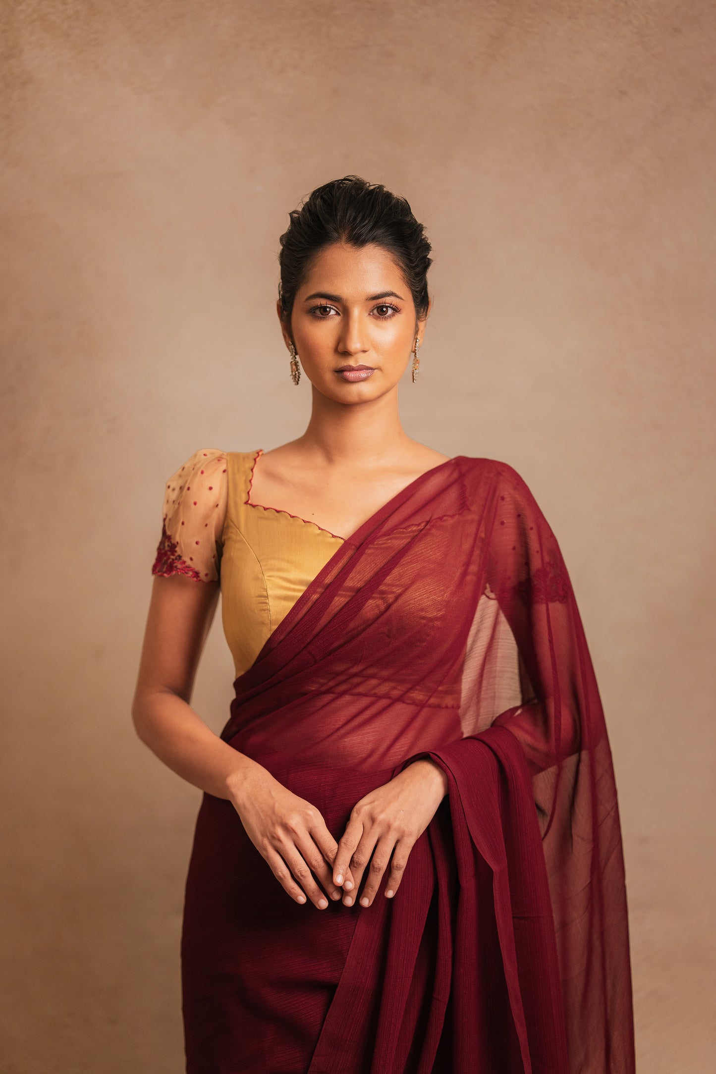 Model Premika Sekar in a saree in maroon tulle embroidered with resham paired with an embroidered satin blouse in light brown by team AKloset.