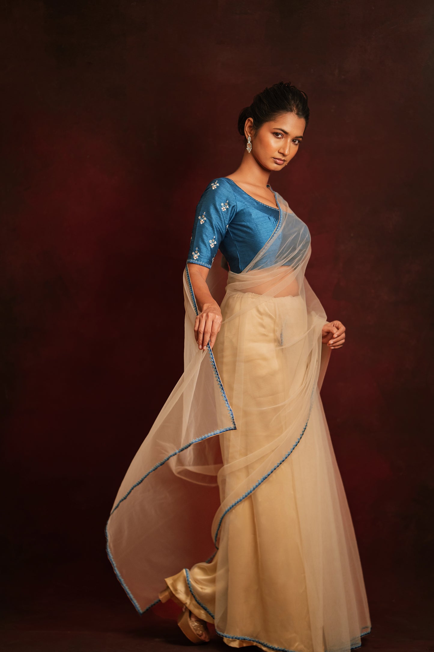 Model Premika Sekar in an ivory tulle saree embroidered with resham paired with an embroidered rawsilk blouse in cerulean blue by team AKloset.