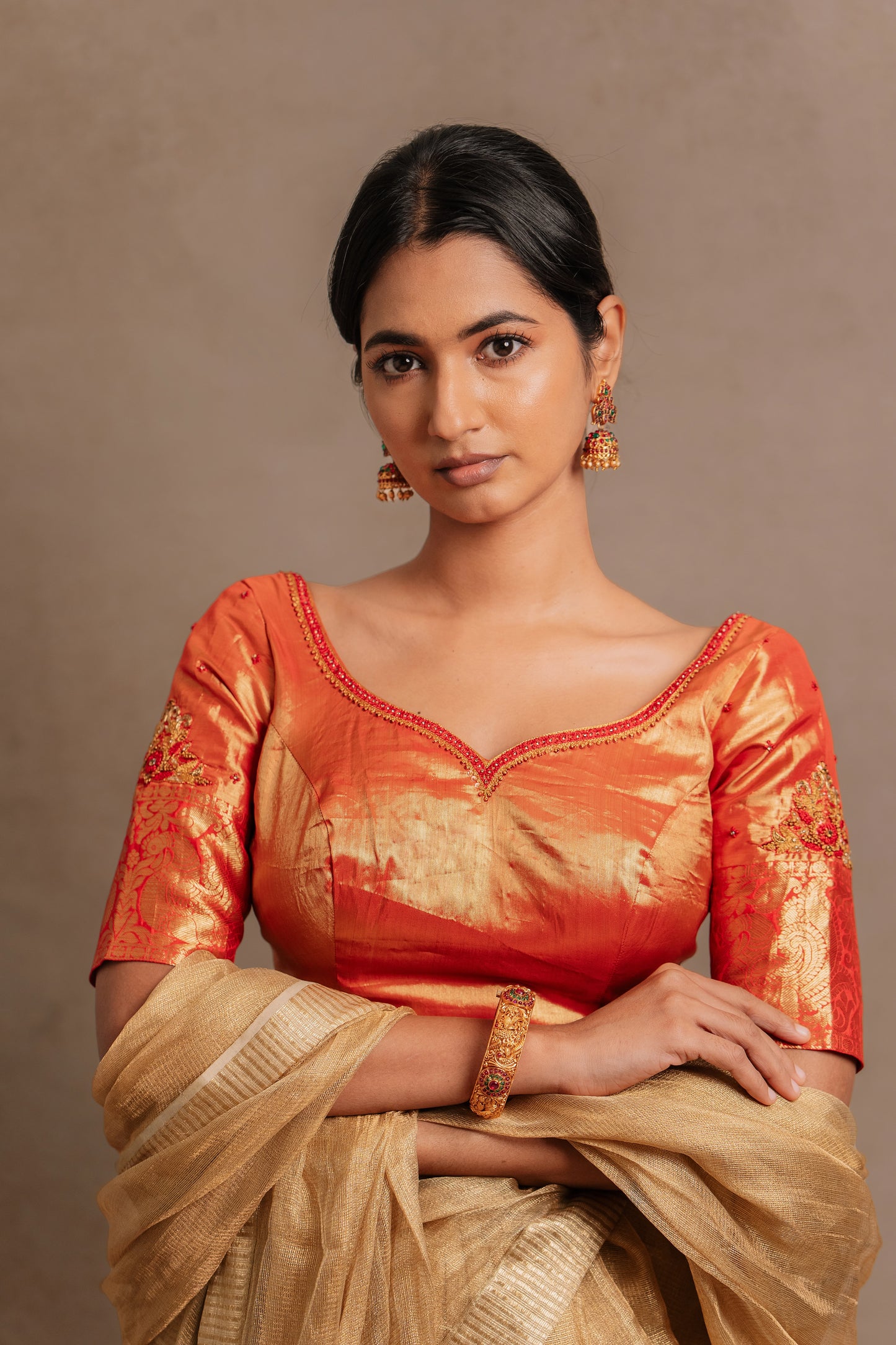 Model Premika Sekar poses in a hand embroidered kanjivaram tissue silk blouse in red (Dual Tone Silk) by team Akloset. Fashionable, high-quality craftsmanship that is stylish and affordable.