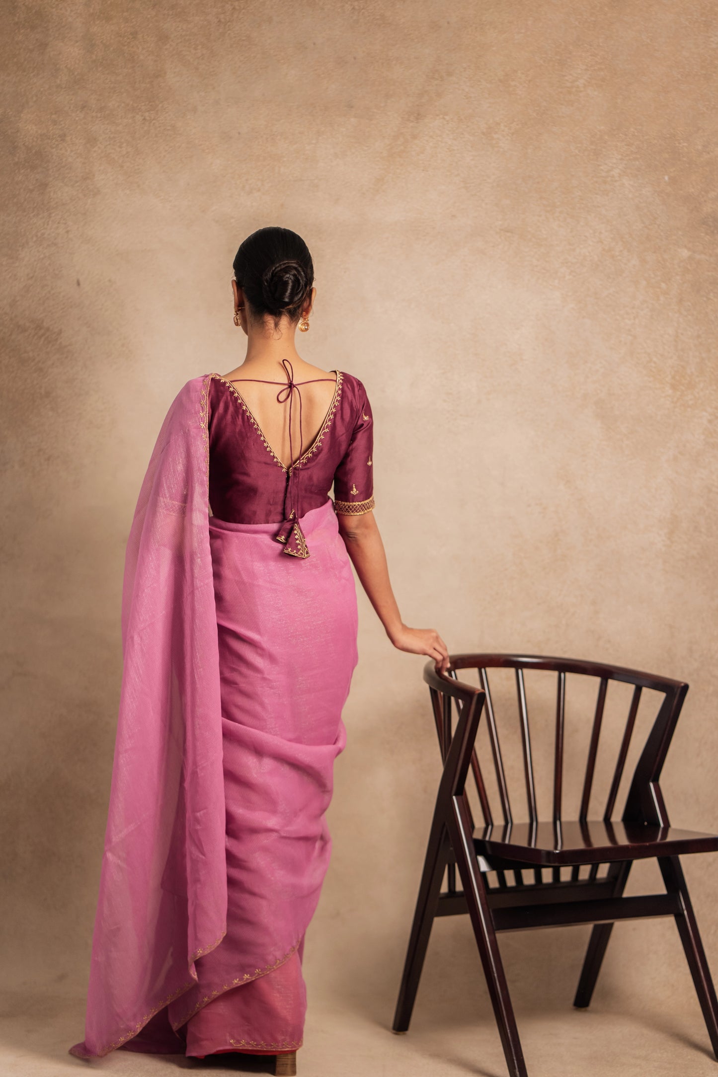 Model Premika Sekar posing for back design in an embroidered Tissue Chiffon Saree in Onion Pink with an Embroidered Chanderi Blouse in Plum.