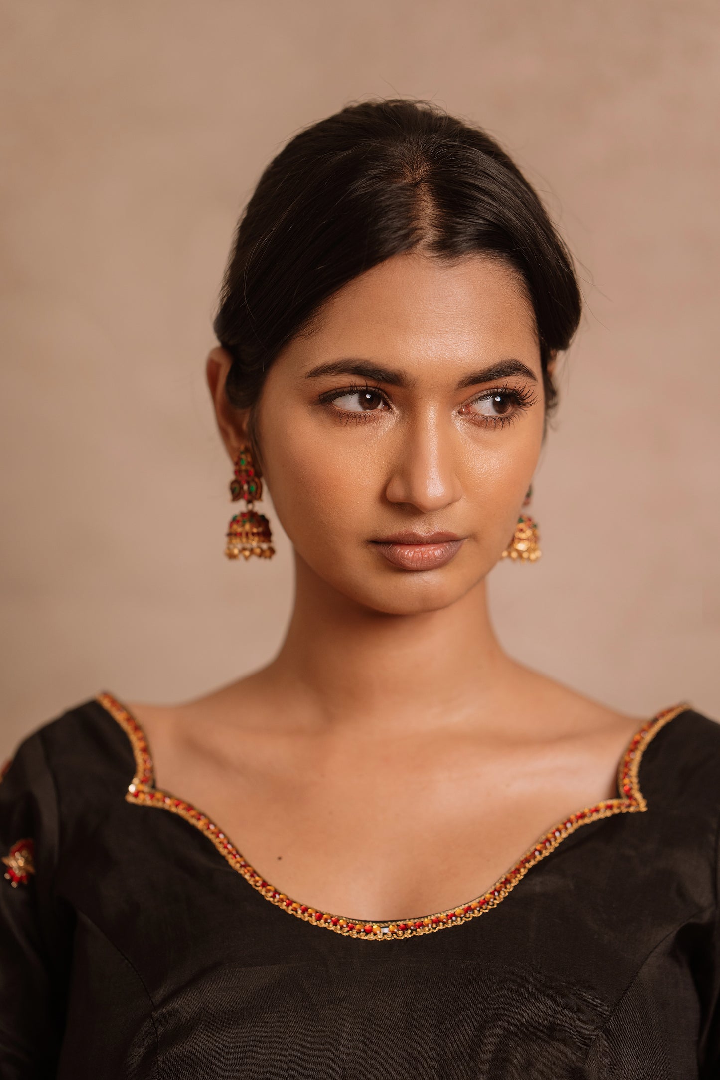 Model Premika Sekar posing for closeup in a hand embroidered kanjivaram silk blouse in black by team AKloset.
