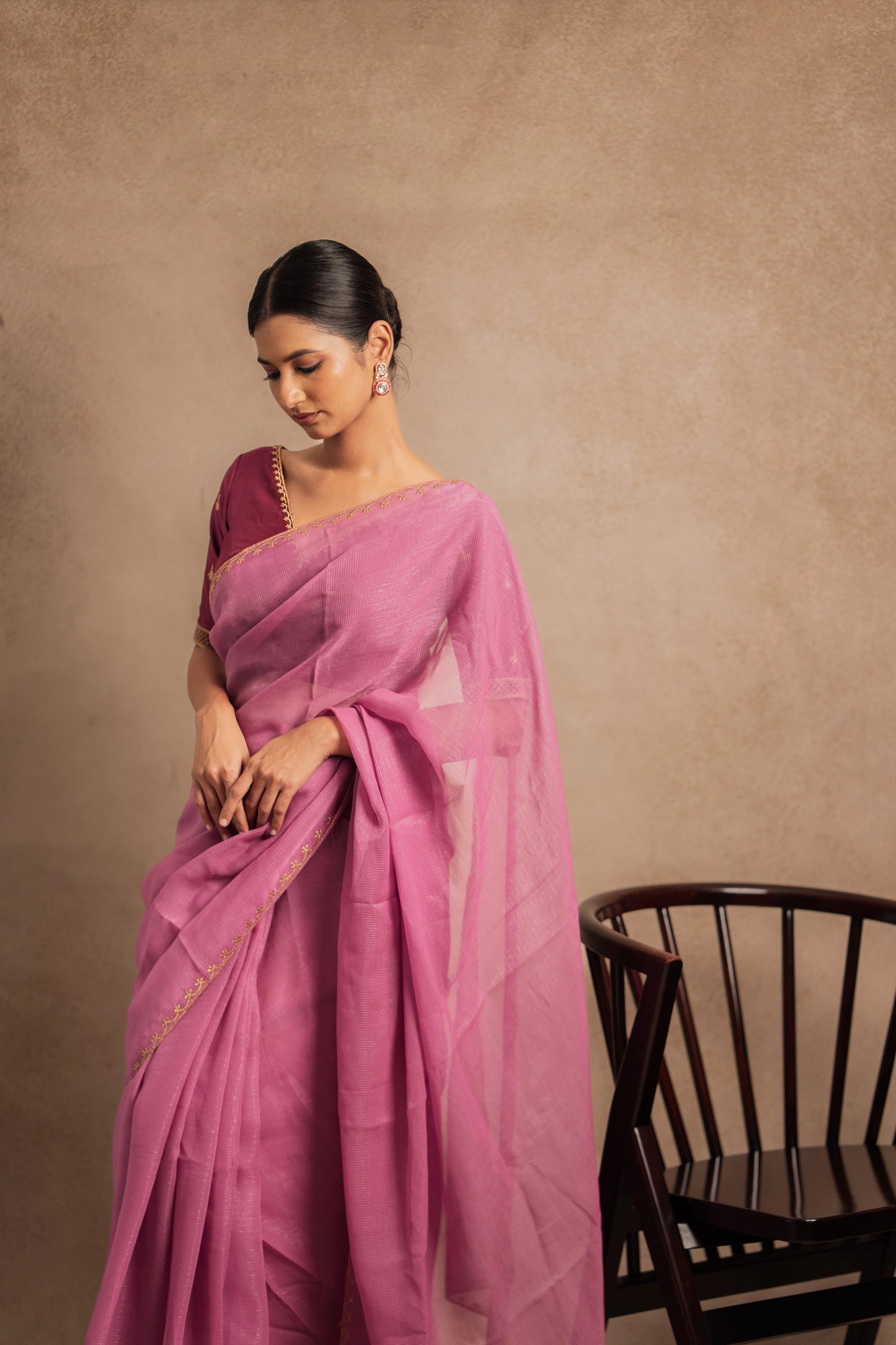 Model Premika Sekar posing for front profile in an embroidered Tissue Chiffon Saree in Onion Pink with an Embroidered Chanderi Blouse in Plum.