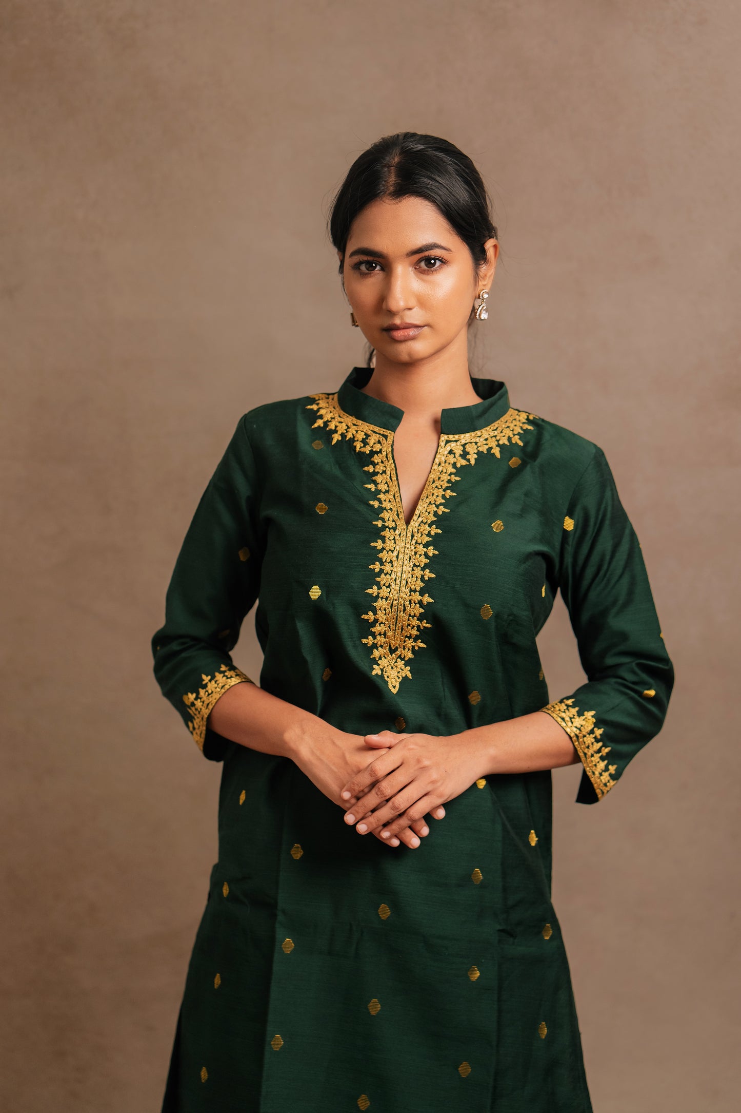 Model Premika Sekar posing for photoshoot in an embroidered jute cotton kurti in bottle green by team AKloset.
