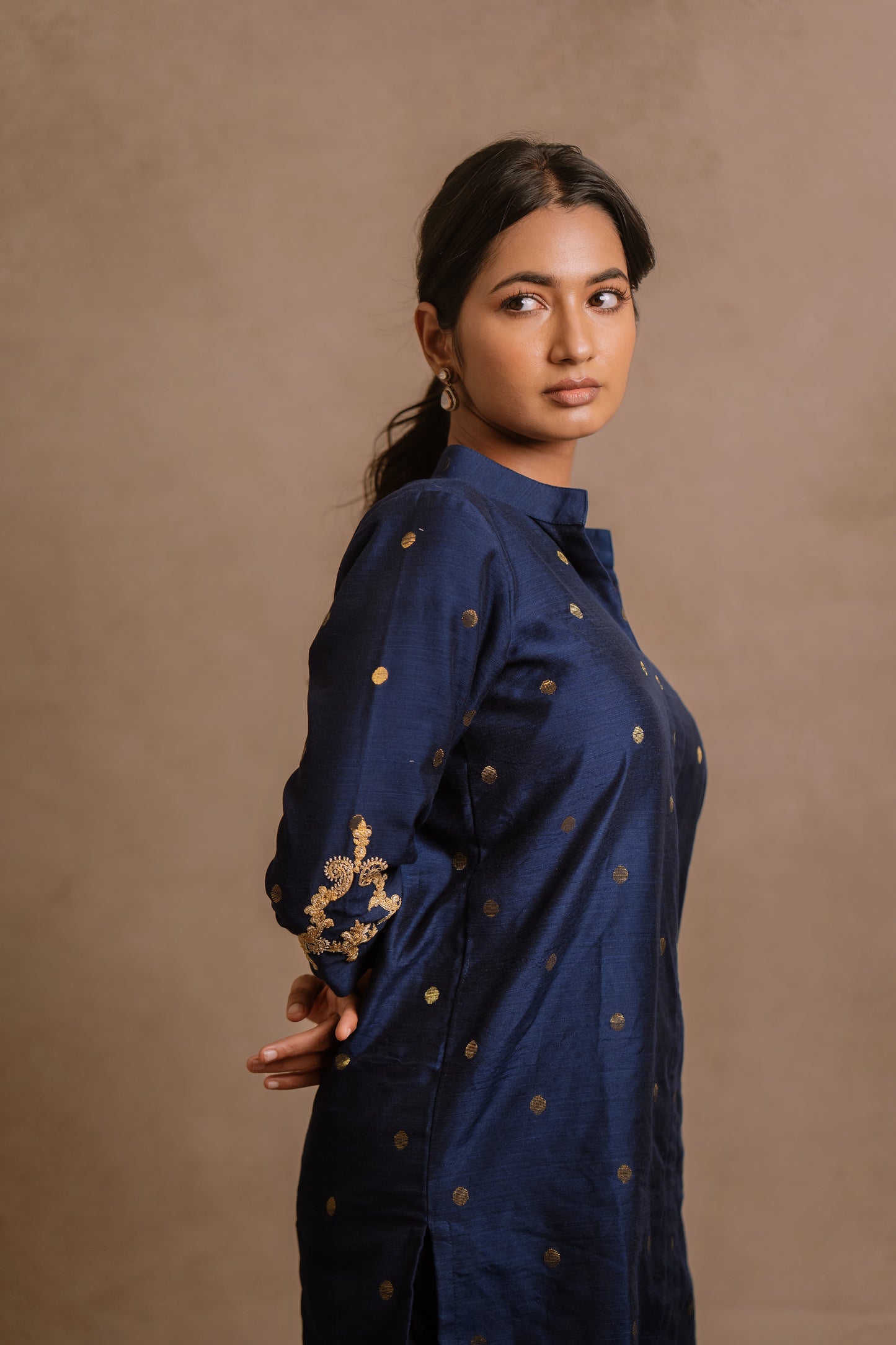 Model Premika Sekar posing for side profile closeup in an embroidered jute cotton kurti set in navy blue by team AKloset.