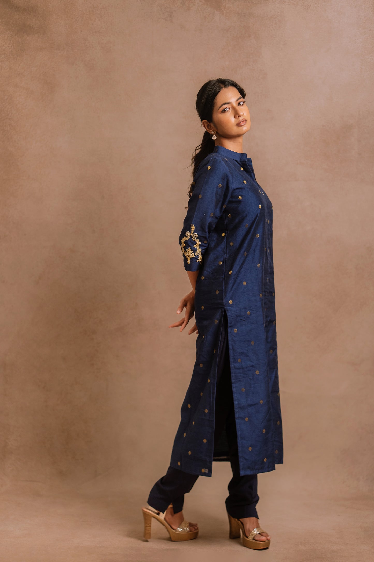Model Premika Sekar posing for side profile in an embroidered jute cotton kurti set in navy blue by team AKloset.