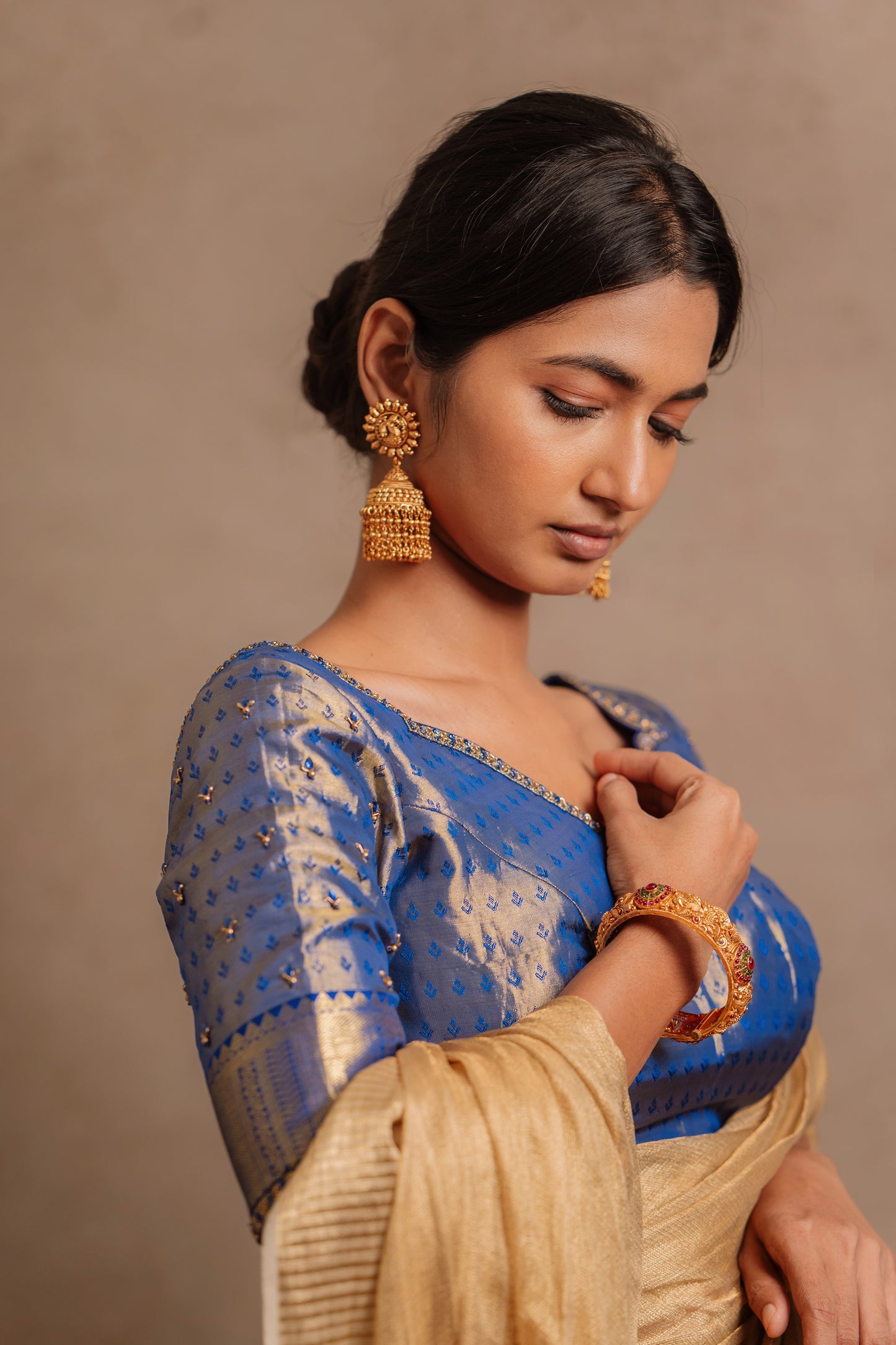 Model Premika Sekar posing in a hand embroidered Kanjivaram tissue silk blouse in blue (Dual Tone Silk) by team AKloset.