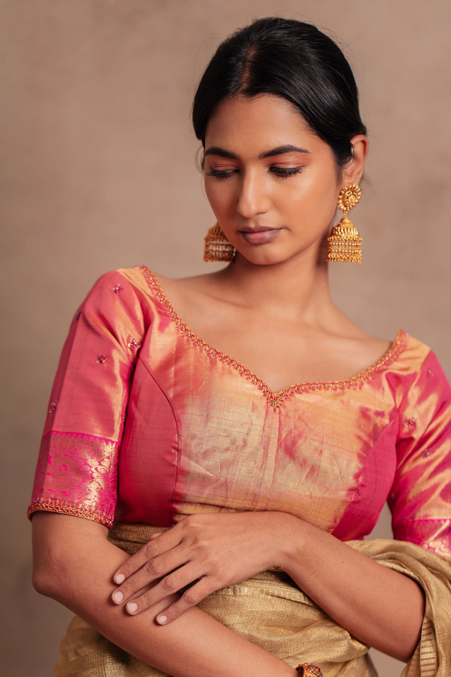 Model Premika Sekar posing in a hand embroidered Kanjivaram tissue silk blouse in pink (Dual Tone Silk) by team AKloset.