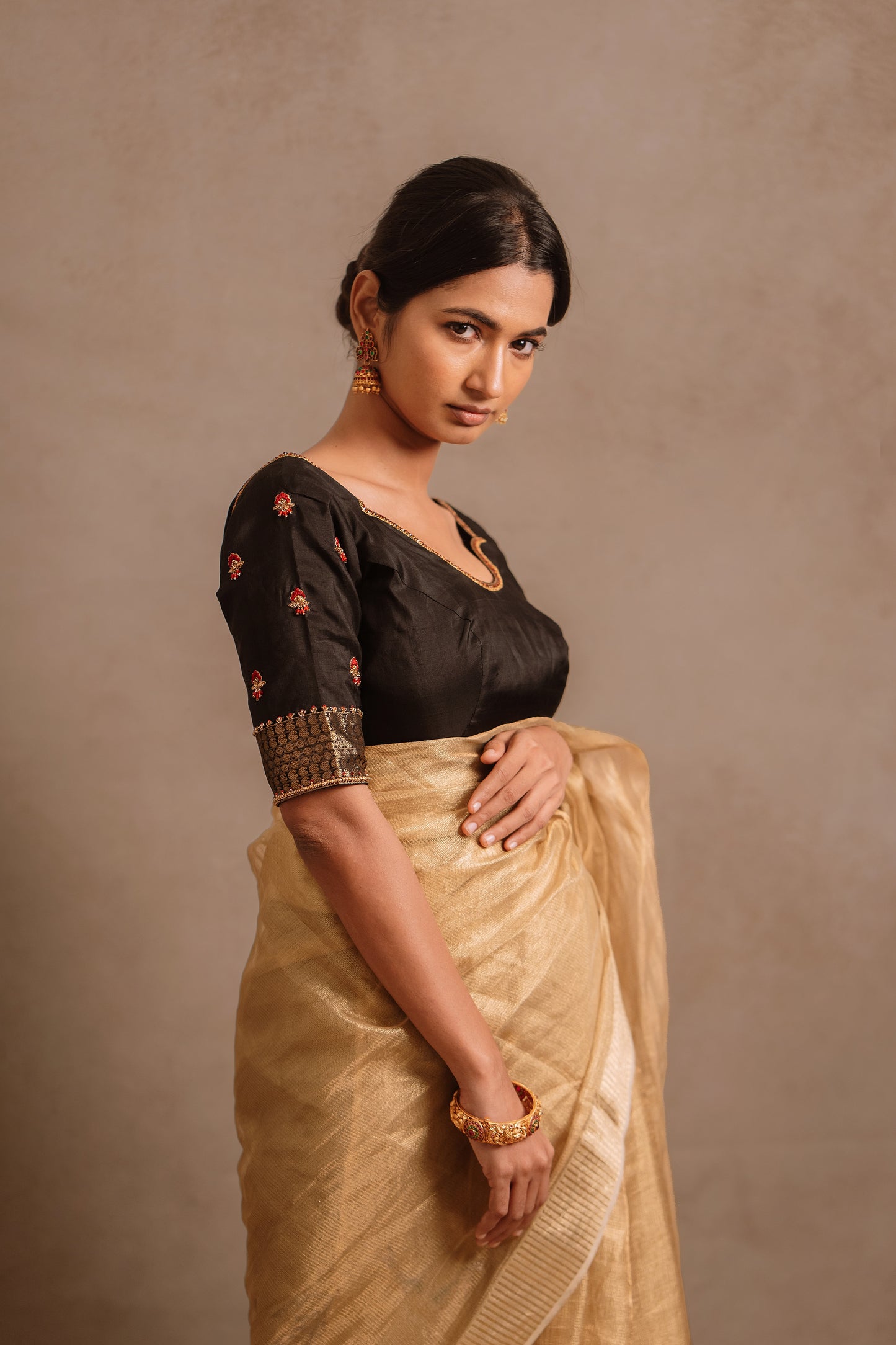 Model Premika Sekar posing in a hand embroidered kanjivaram silk blouse in black by team AKloset.
