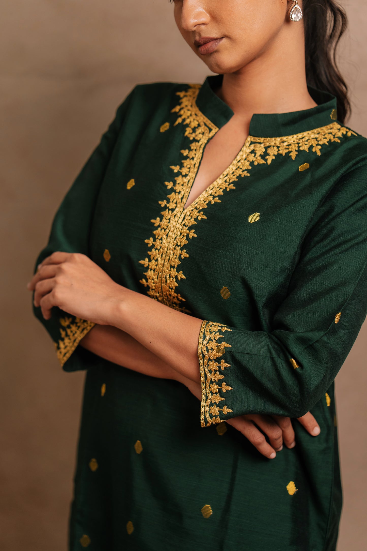 Model Premika Sekar showcasing neckline and sleeve in an embroidered jute cotton kurti in bottle green by team AKloset.